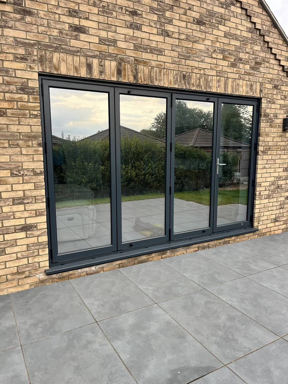 Large black-framed glass sliding doors with window film fitted