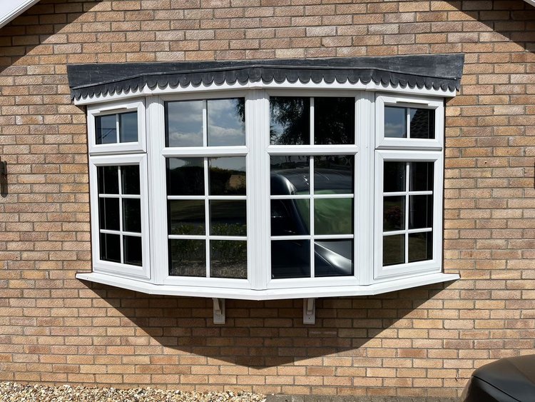 Large bay window with white framing and window film
