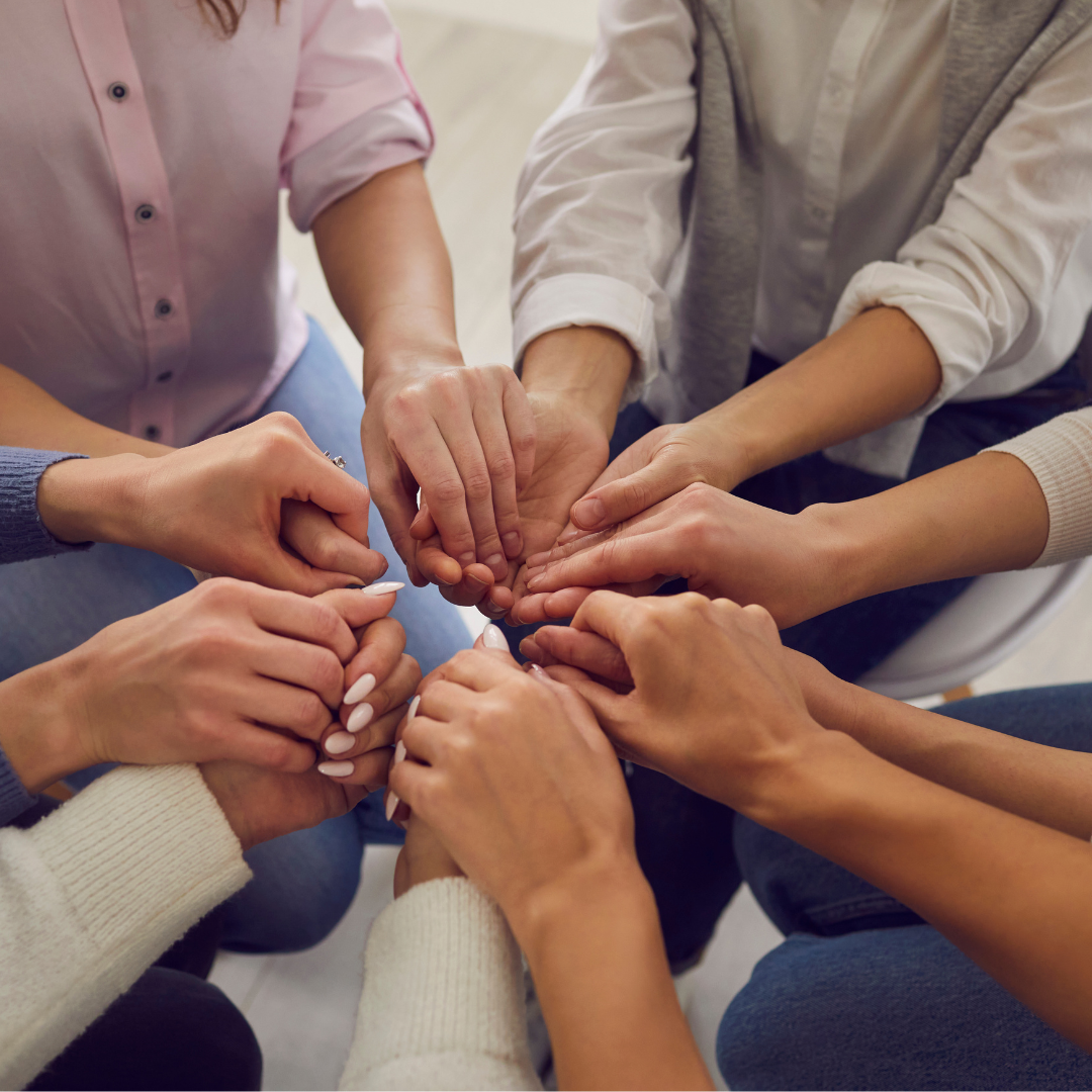 A bright pink female figure standing confidently apart from a crowd of white female figures, symbolizing leadership, individuality, and standing out from the crowd.