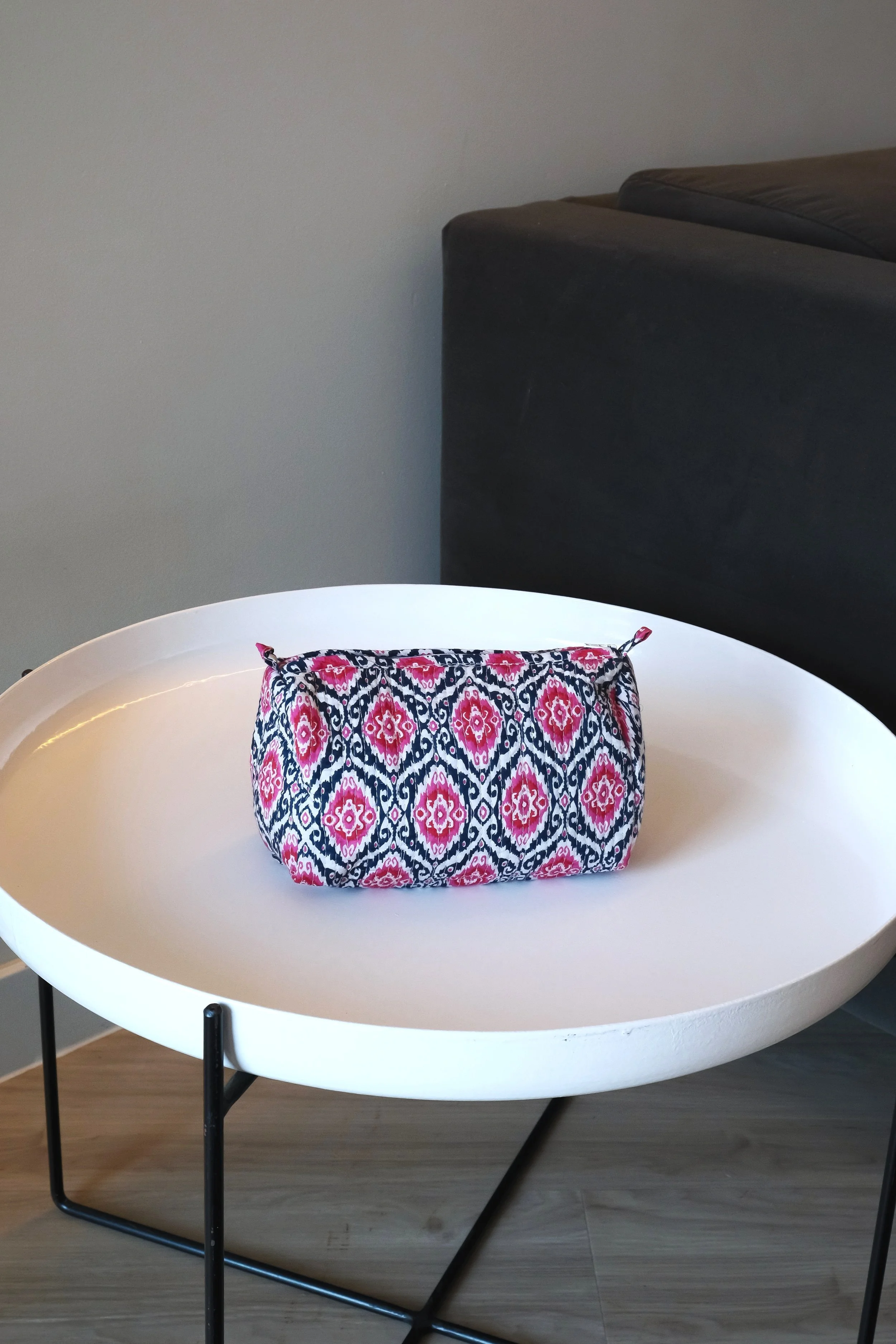 Bolsa estampada sobre mesa blanca redonda en una sala de estar.