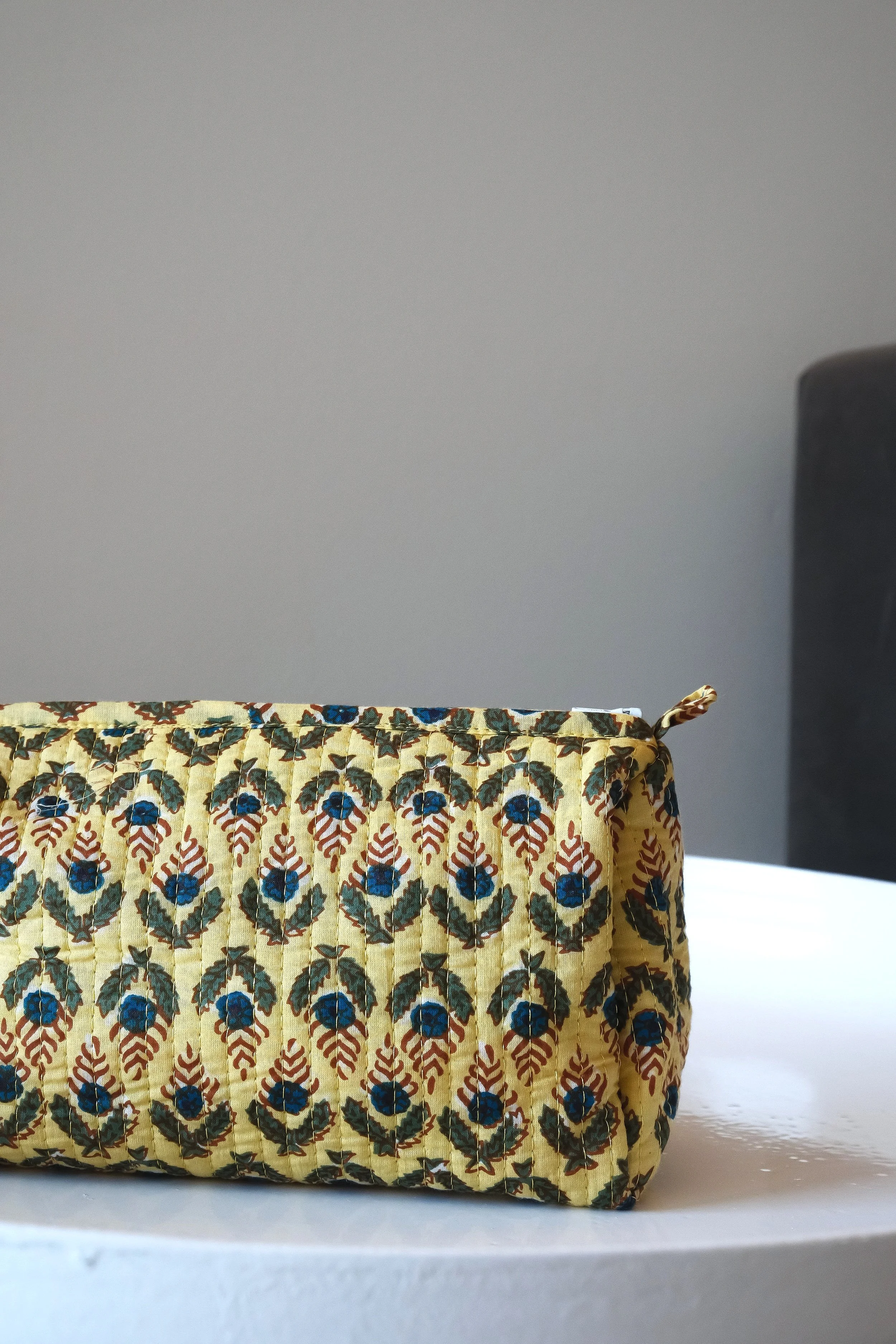 Bolsa de tela estampada con motivo floral en una mesa blanca.