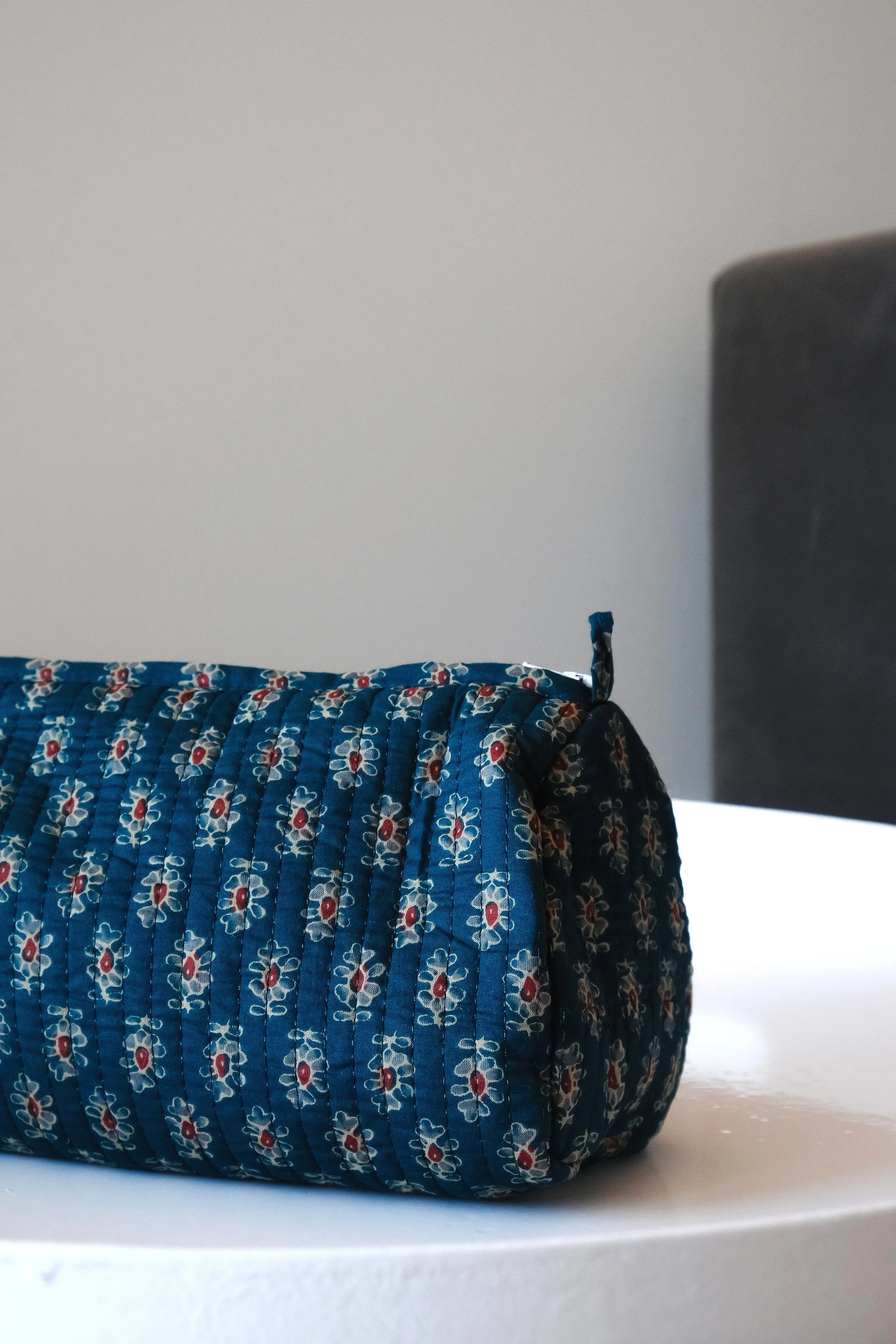 Bolsa de tela azul con estampado floral sobre una superficie blanca.