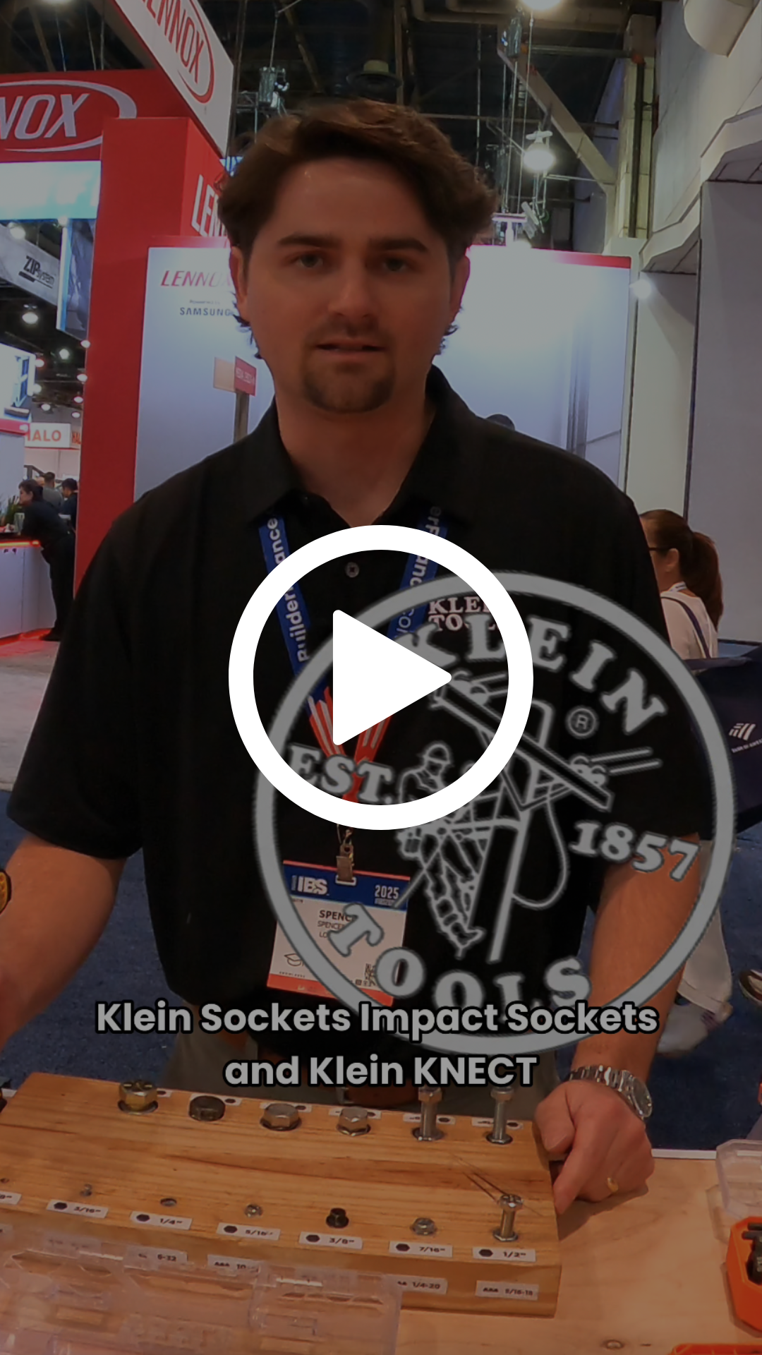 Man showcasing Klein sockets and Klein Impact Sockets at an exhibition booth with a display of various sockets on a wooden board.
