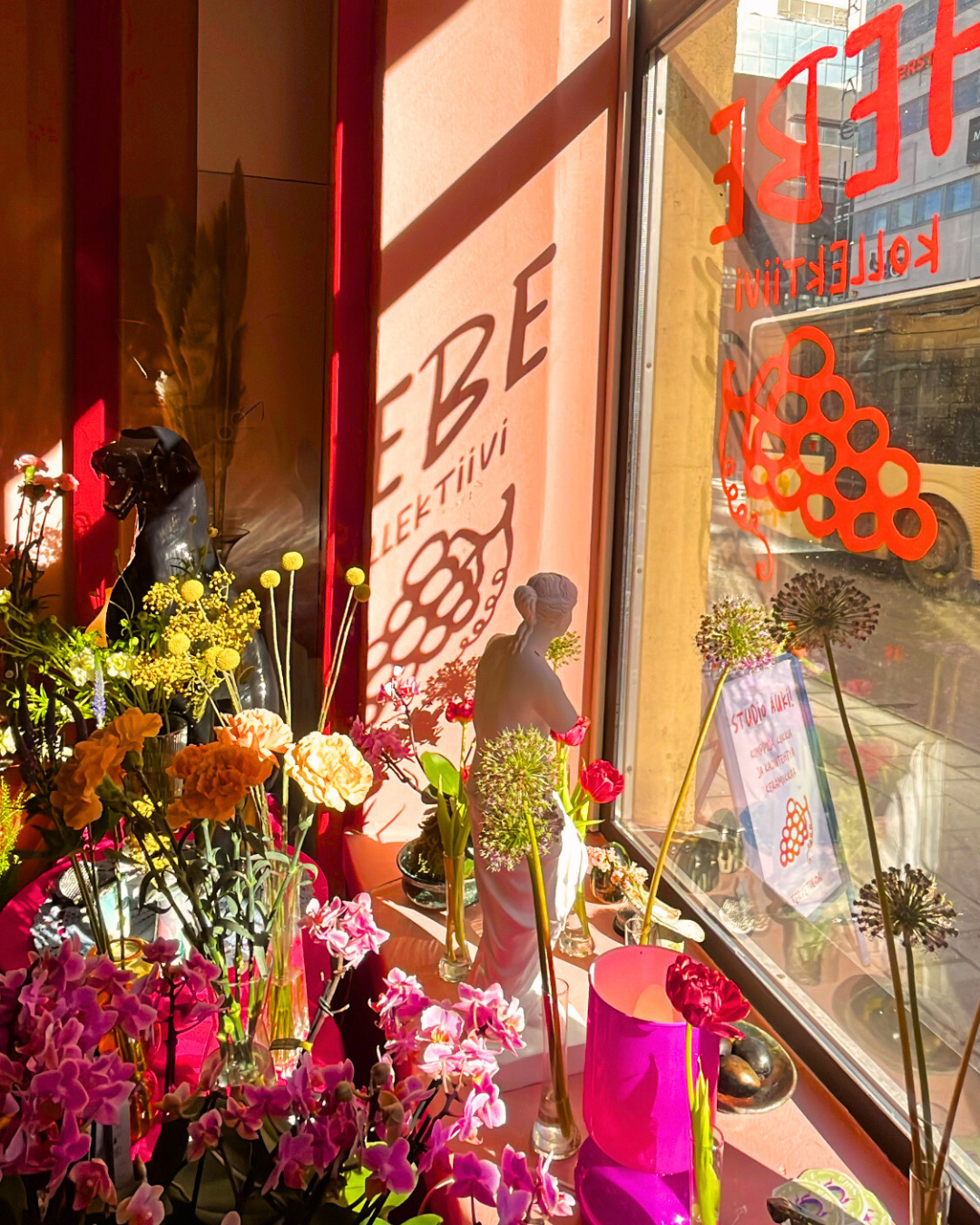 Hebe Kollektiivin ikkuna, jossa on esillä Studio Sulan kukkia. Ikkunasta näkyy Kupittaan Itäinen Pitkäkatu.