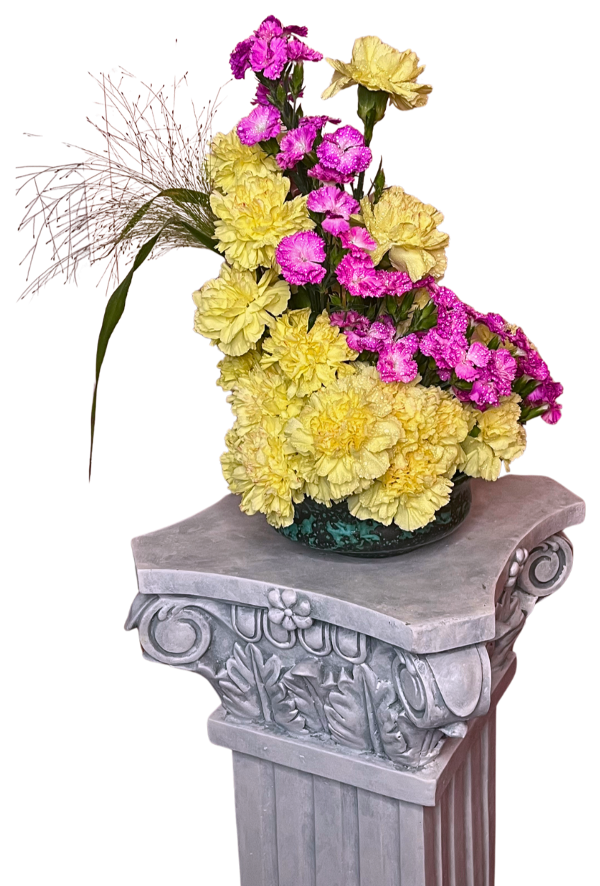 Kukka-asetelma keltaisista ja pinkeistä neilikoista kreikkalaisella pylväällä