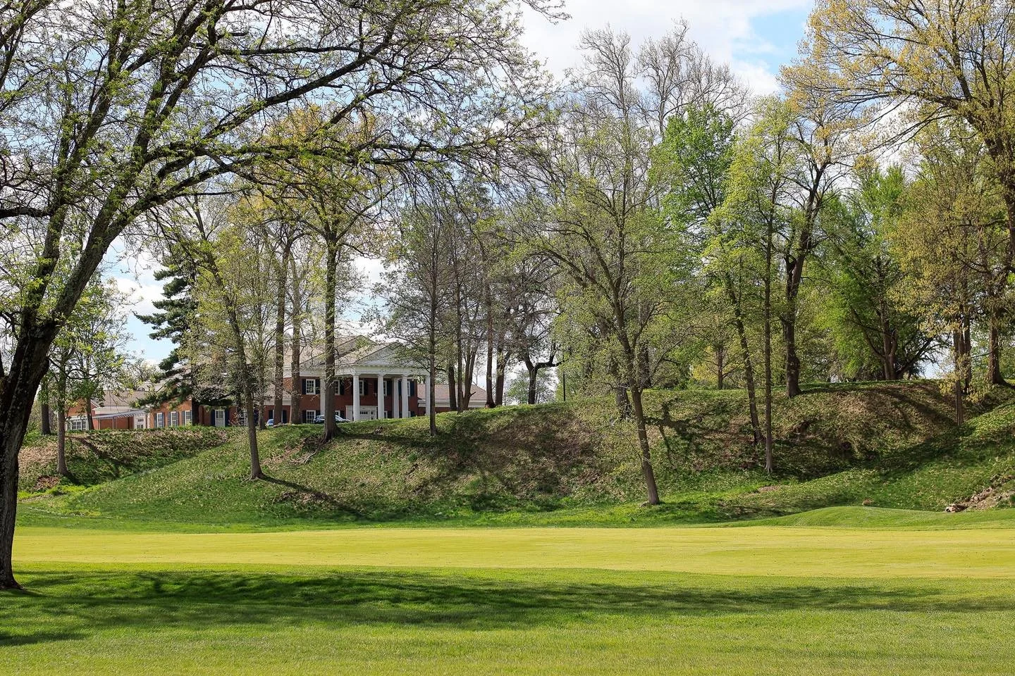 The framing of the fairway on Hole 1 and the classic architecture of the Clubhouse all come together with a kind of easy sophistication. It is polished, picturesque, and exactly the sort of springtime vibe that stays with you even after the round end