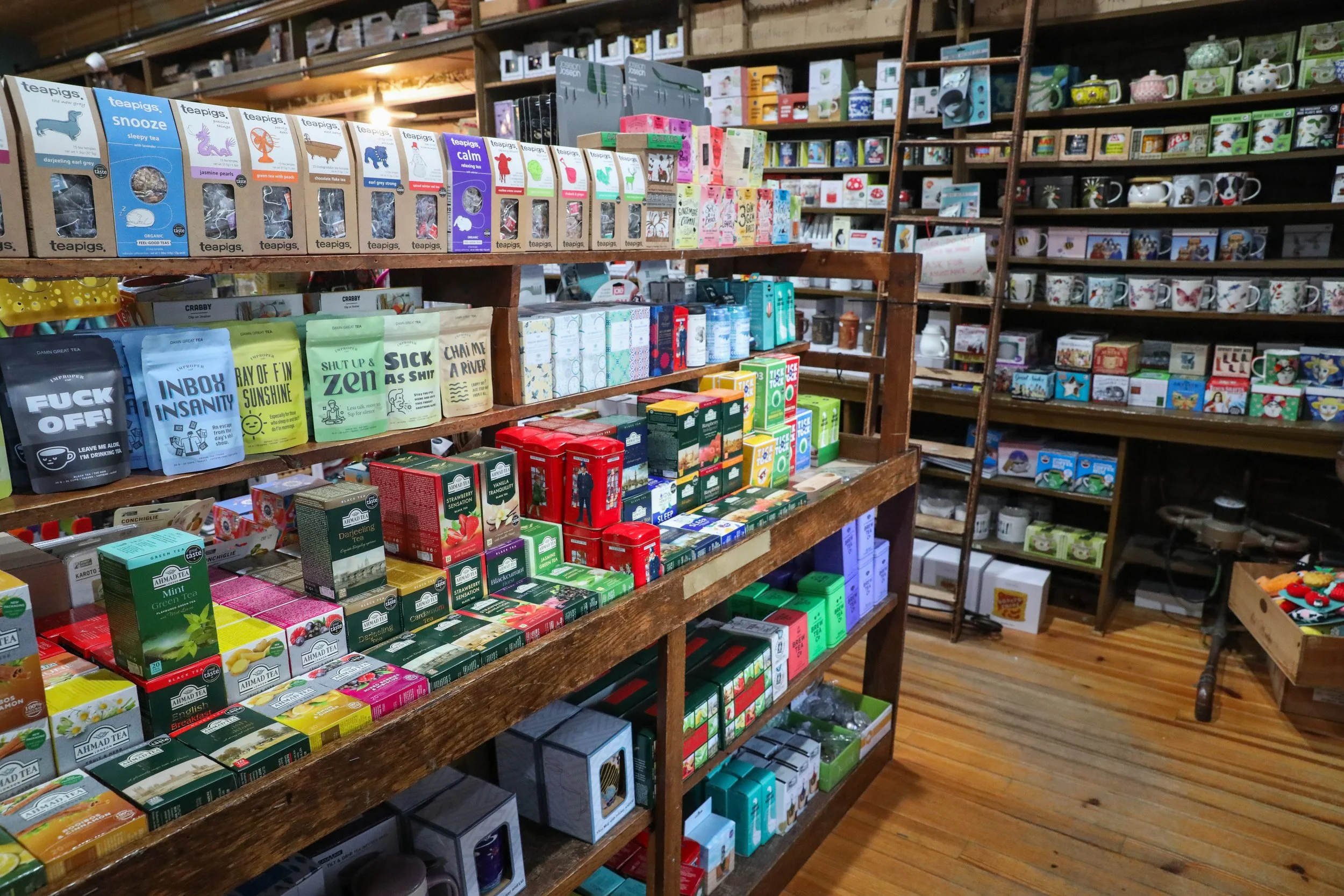 Wooden Shelves full of colorful boxes of different types of teas and tea accessories inside Franklins General Store in Hyattsville, MD.