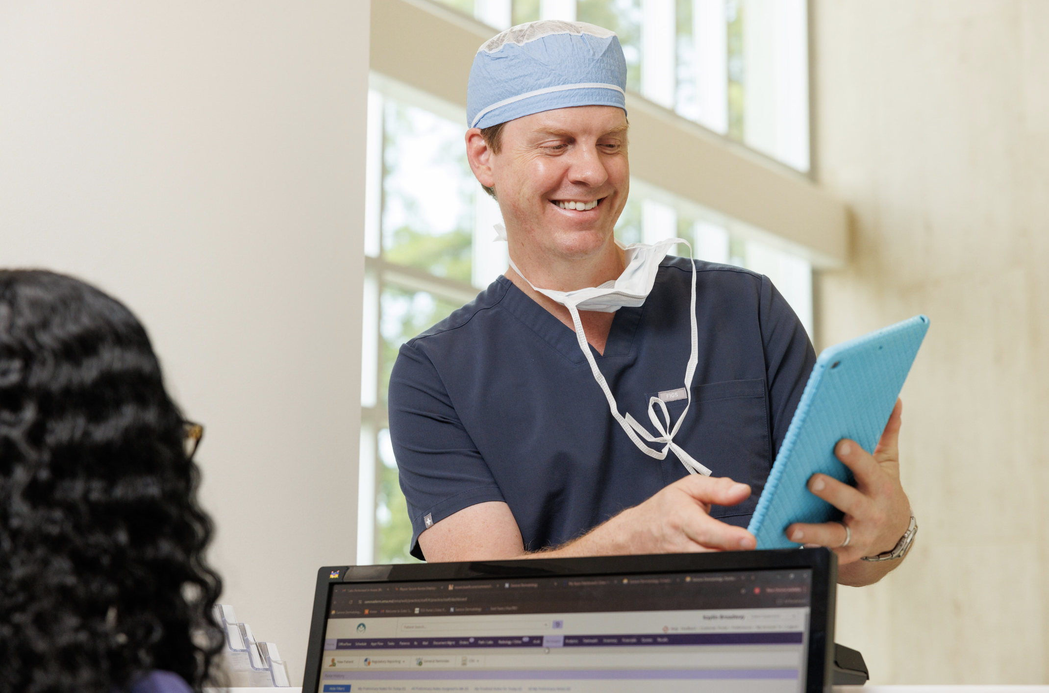 Dr. Chad Prather reviewing a patients information before Mohs surgery at Derma
