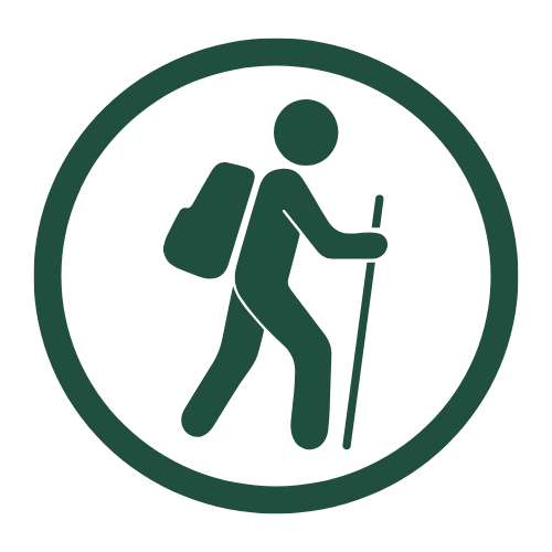 Icon of a hiker with a backpack using a walking stick, enclosed in a circle.