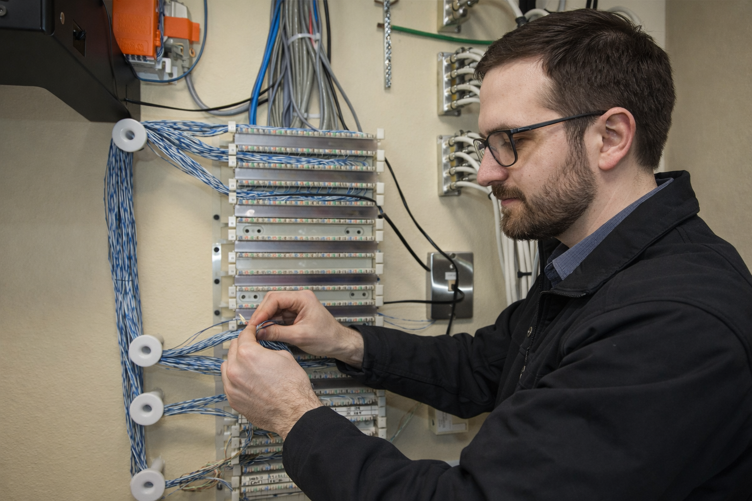Lead technician performing troubleshooting and repair work on commercial network cabling in Louisiana.