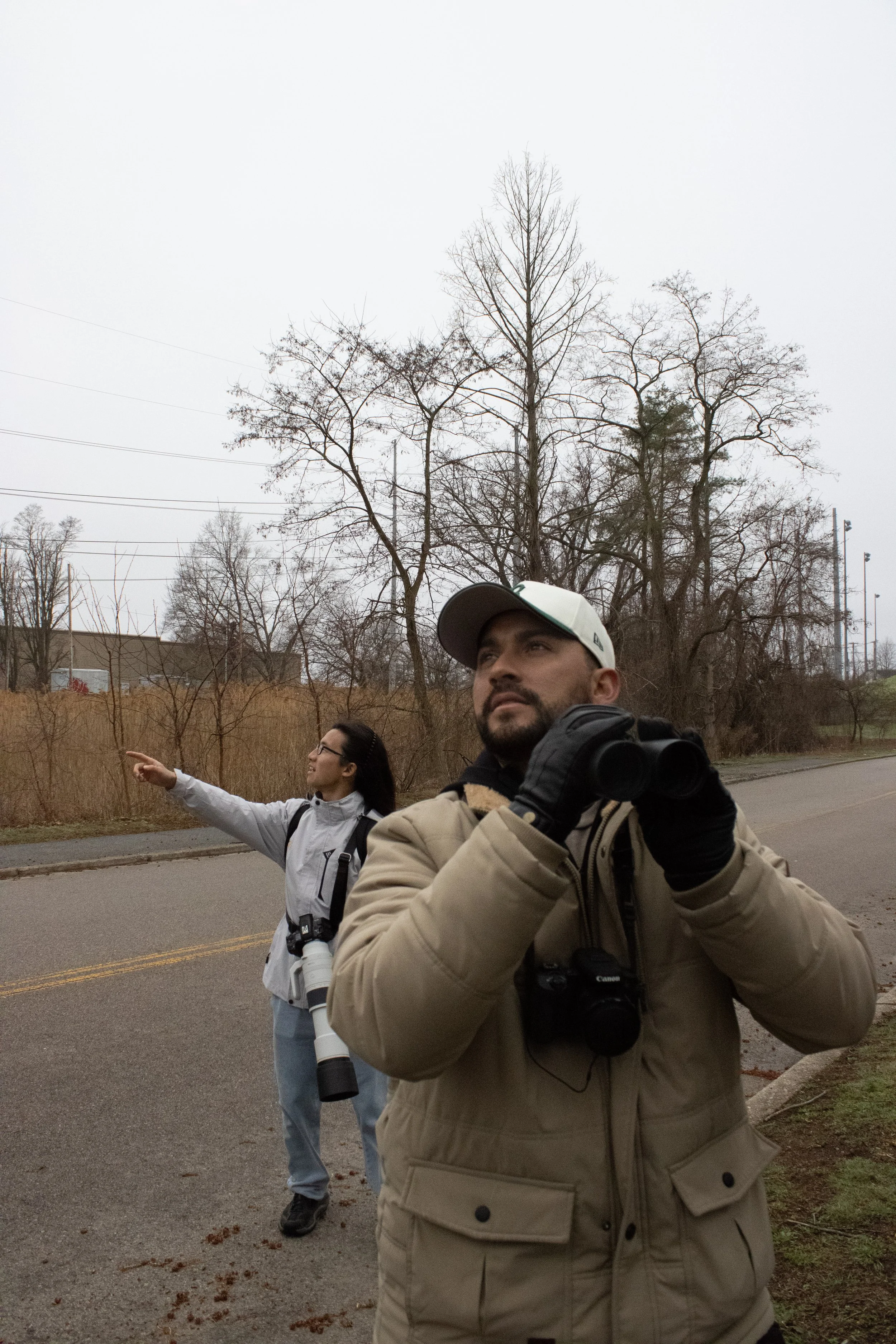 Nicholas Komar, 32, and McQueen Chen, 19, birdwatching near the abandoned high school in Millenium Park, Roxbury, MA.