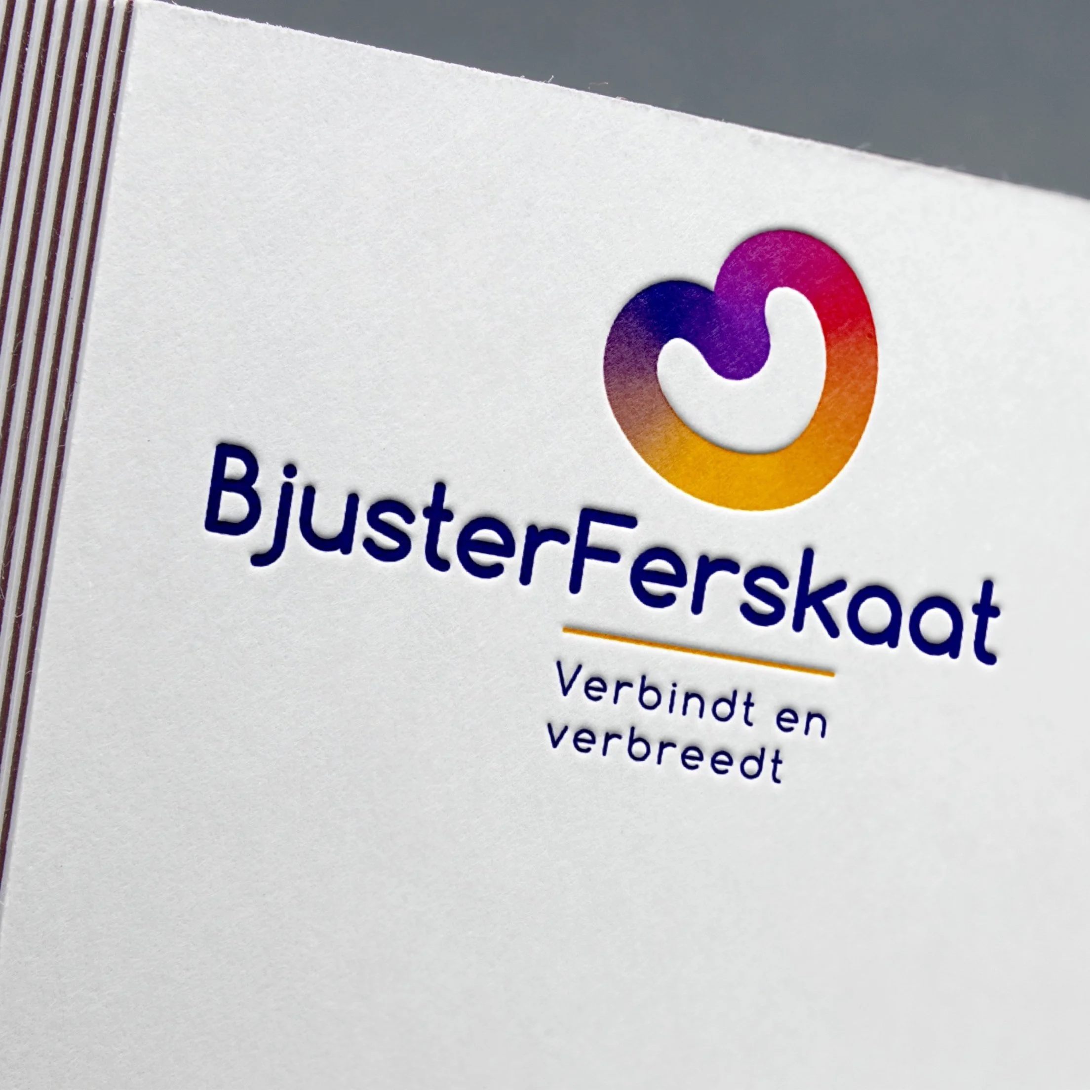 Close-up van een kaart of flyer met het logo en de naam 'BusterFerskaat' en de slogan 'Verbindt en verbreed'.