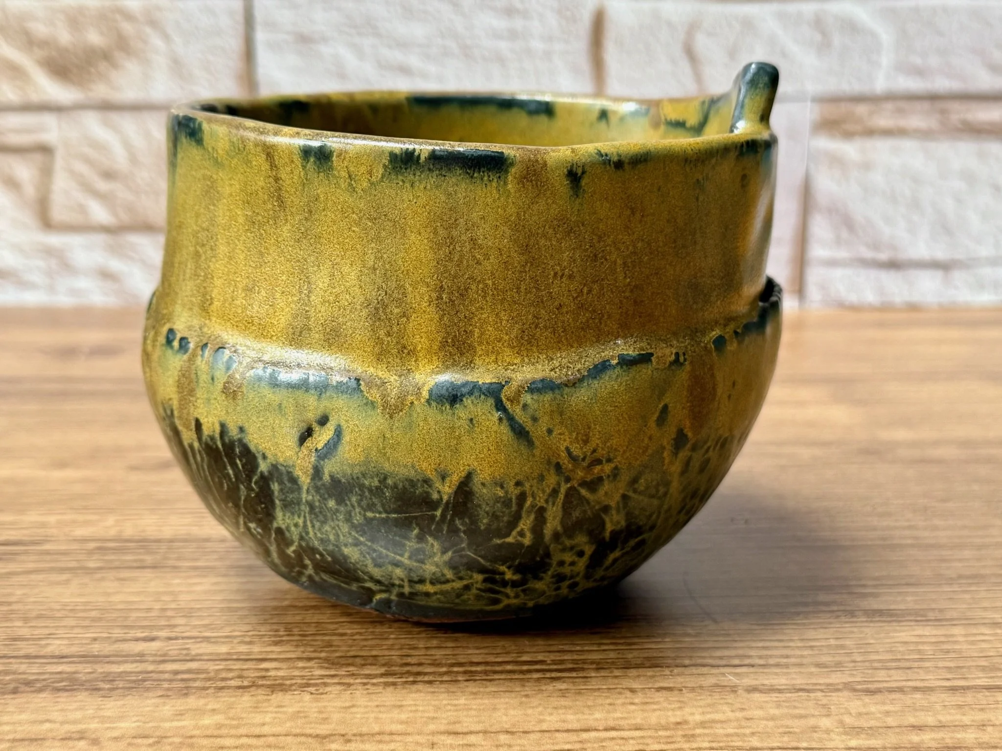 Small two-tone bowl with deep red over black matte glaze and crisp profile.