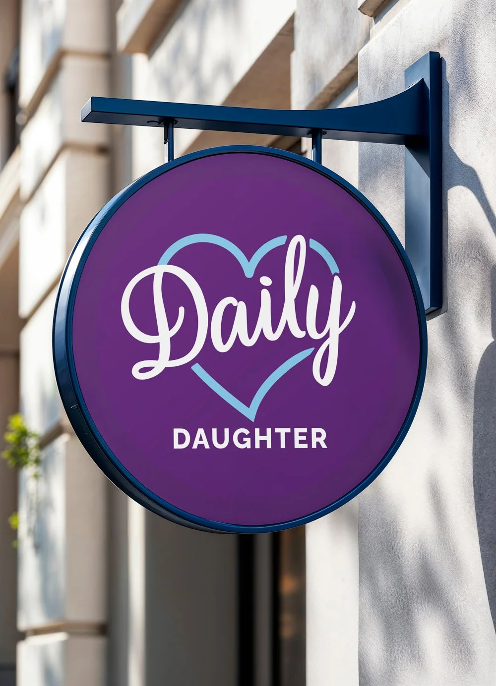 A circular purple sign with the words "Daily Daughter" written in white, surrounded by a light blue heart outline, mounted on a wall outside.