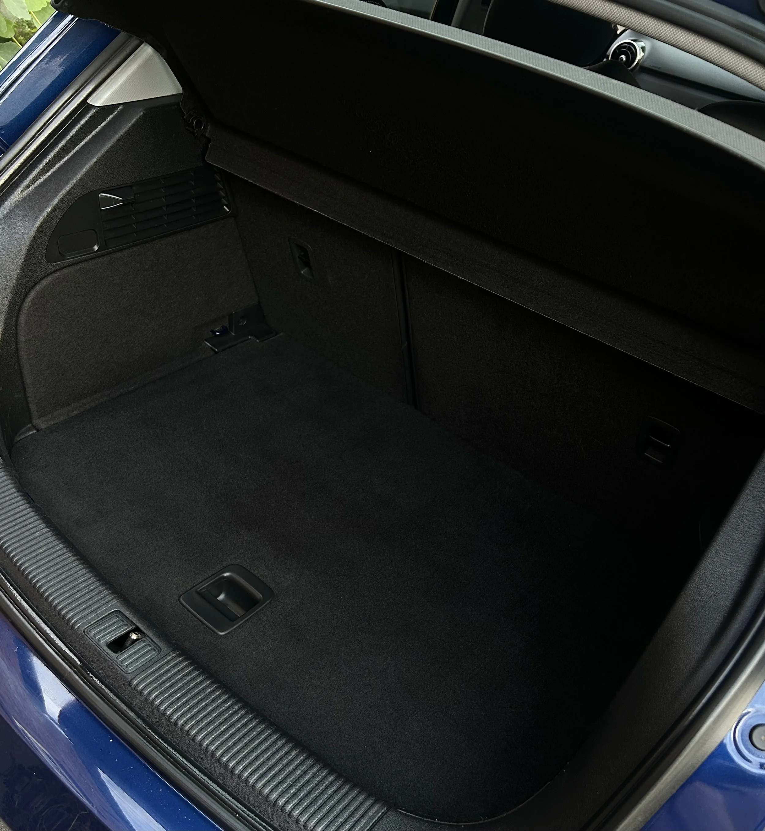 Empty car trunk with black interior carpeting
