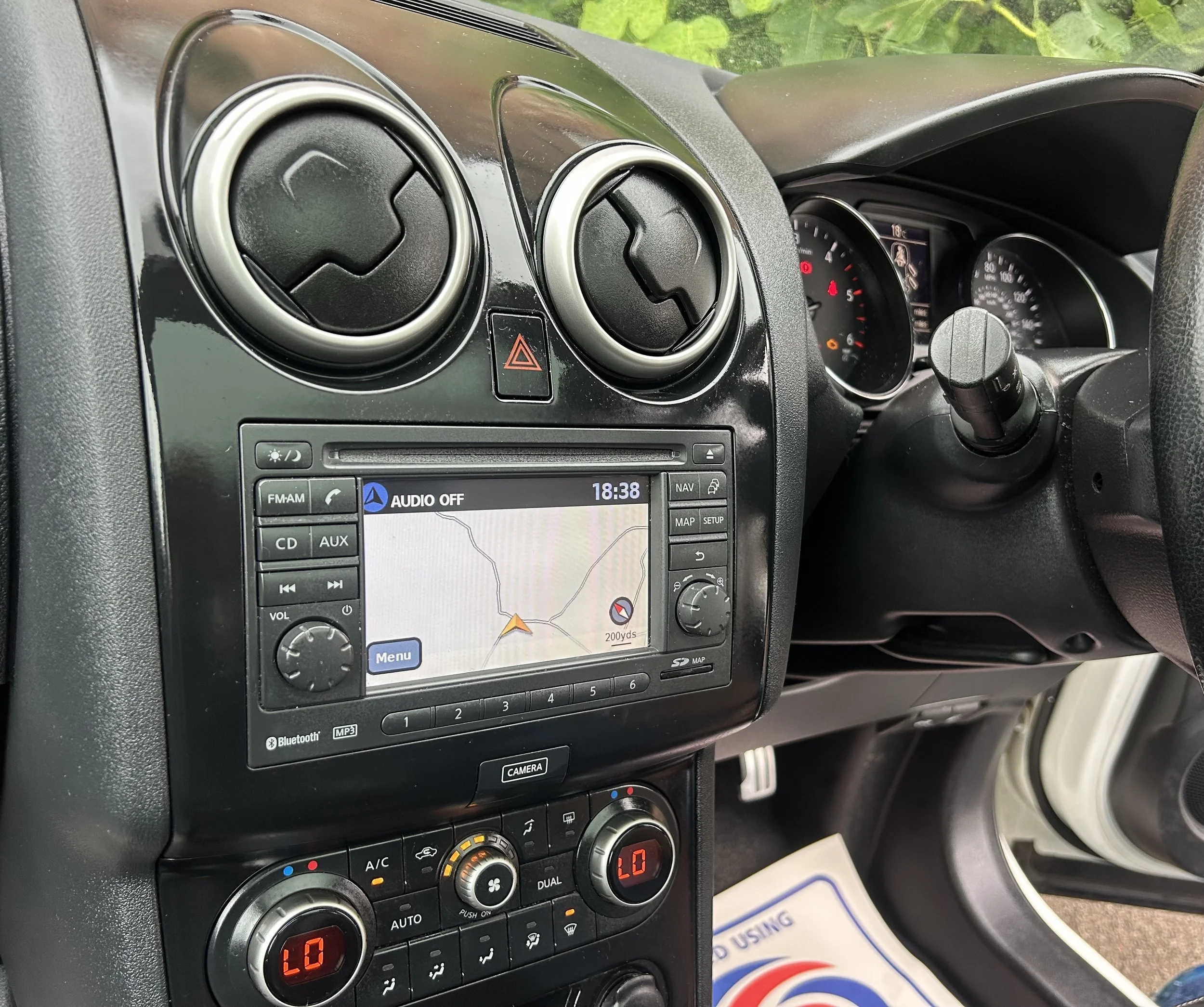The interior of a car showing the dashboard, GPS navigation screen, air vents, car controls, and part of the steering wheel.
