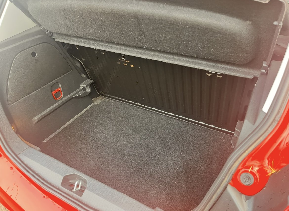Empty car trunk with black interior and red exterior visible at the sides.