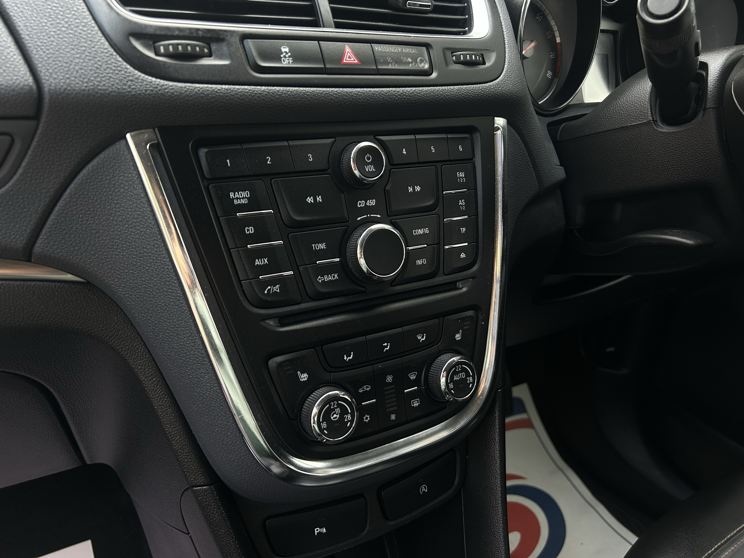 Close-up view of a car's center console showing various controls, including volume knob, radio, and climate control dials.