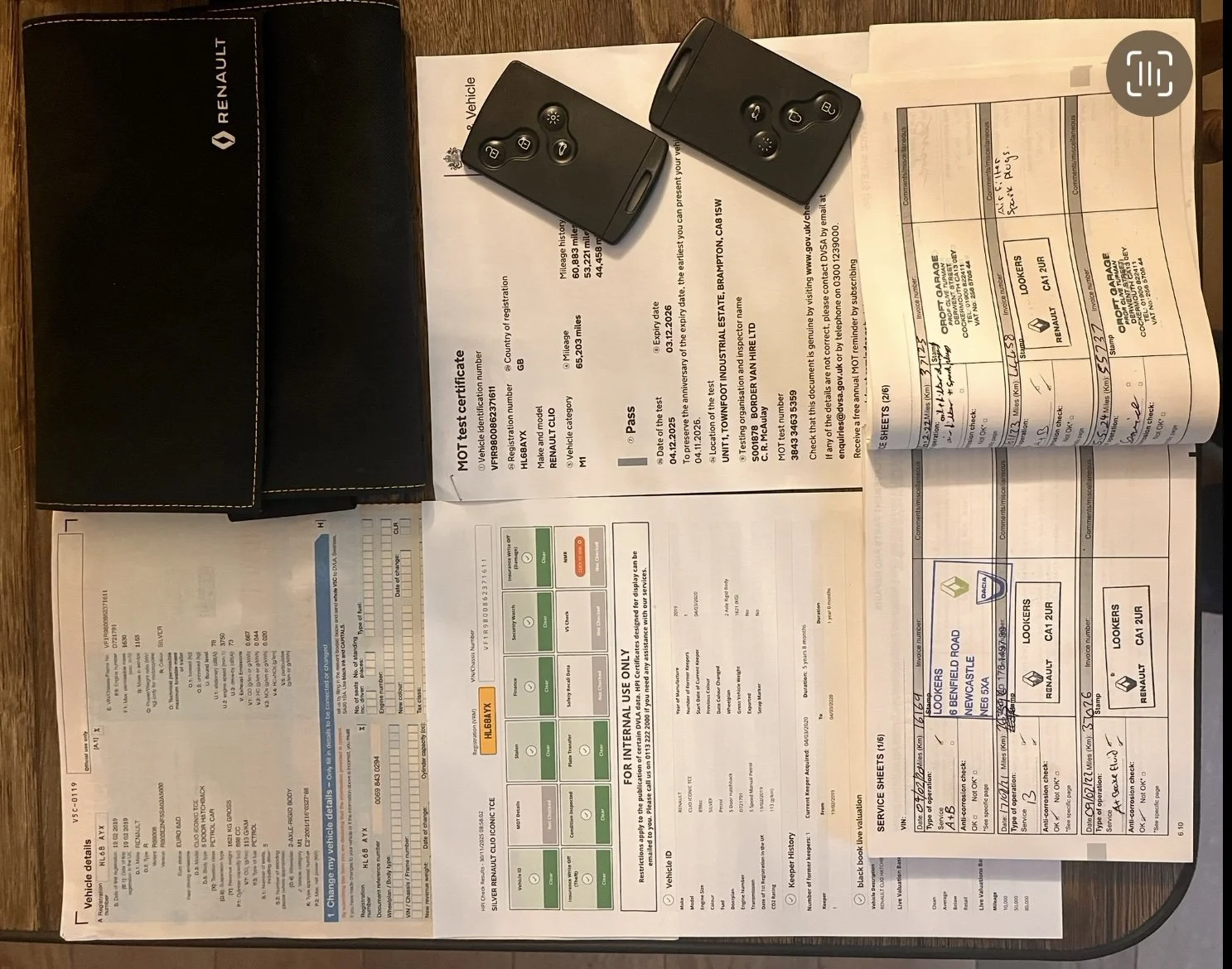 Car keys and vehicle documents on a table.