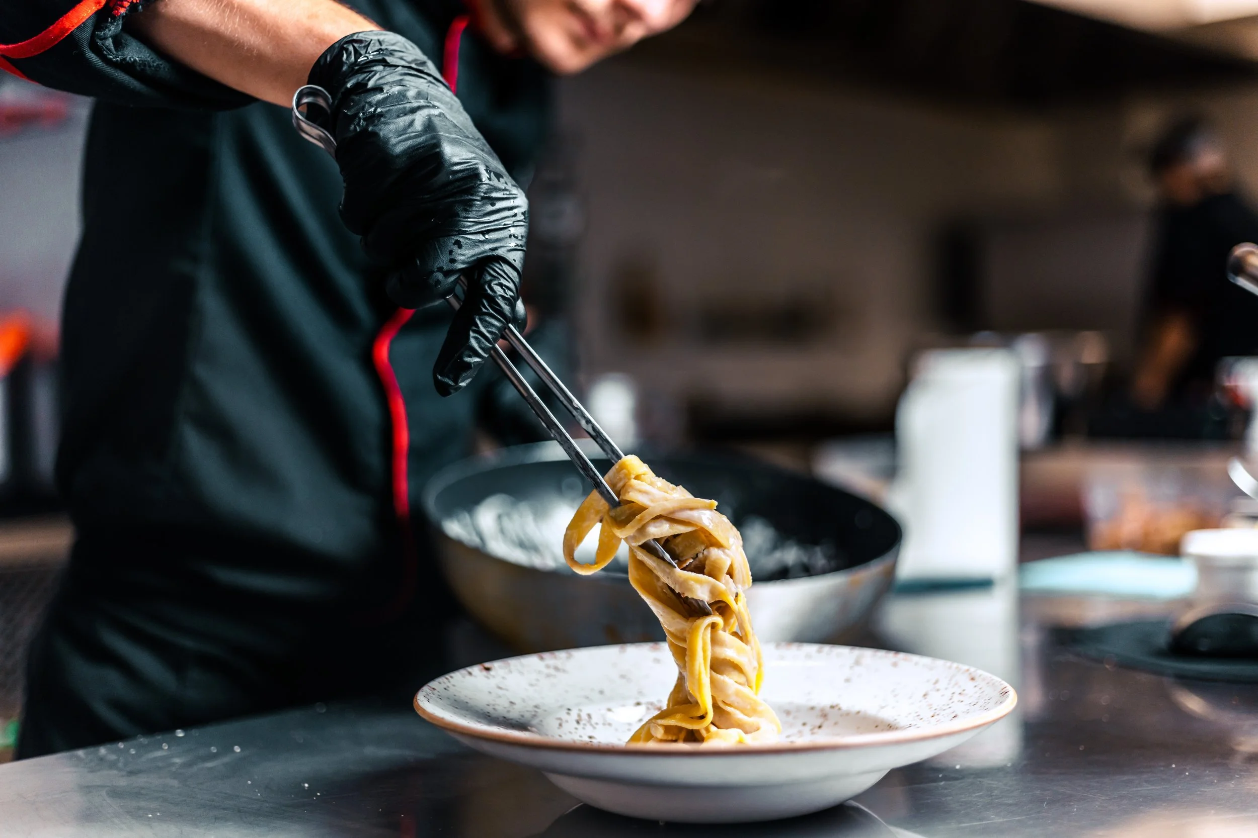 Chef plating pasta_iStock-1411983737.jpeg
