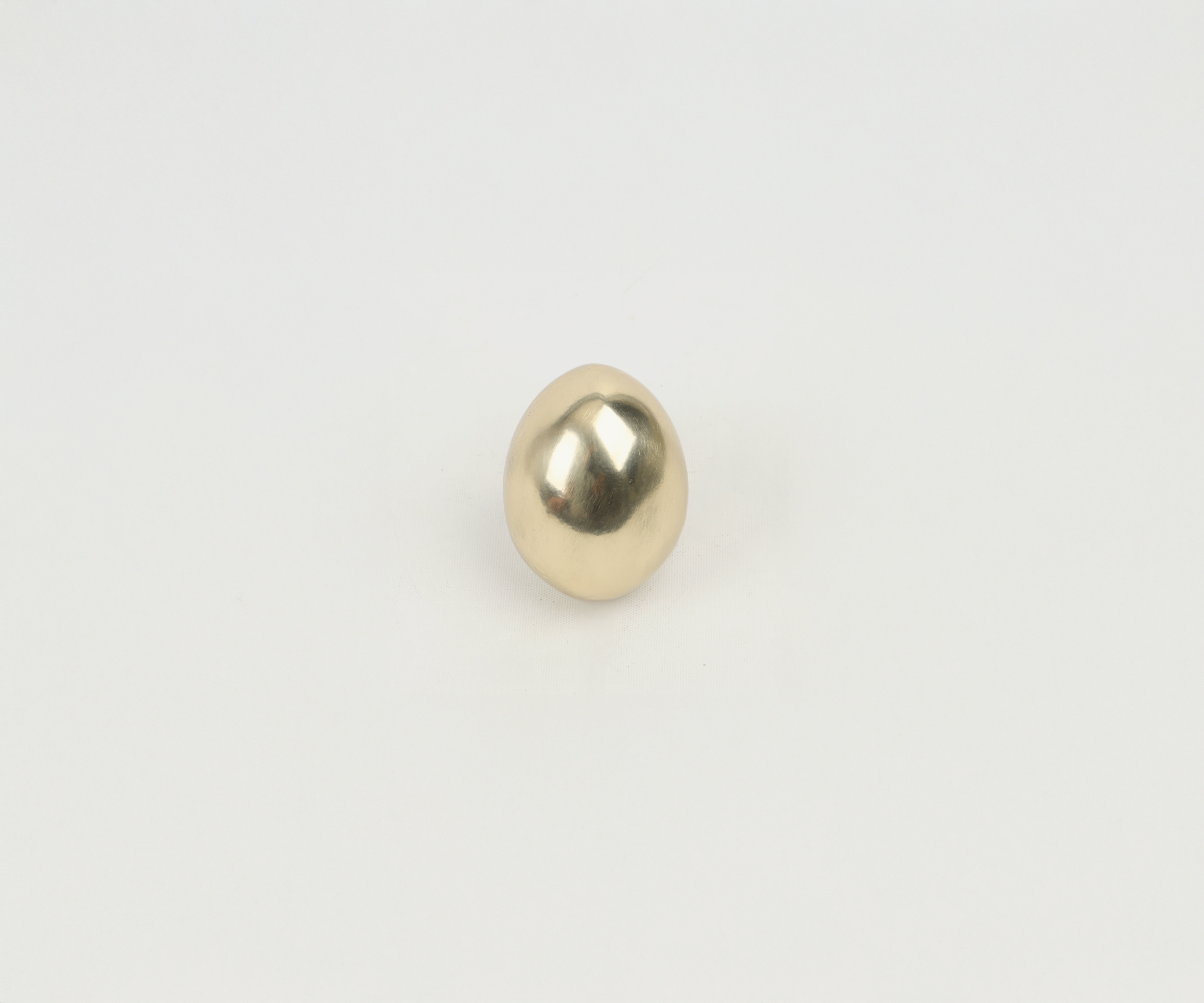 Gold-colored egg on white background.