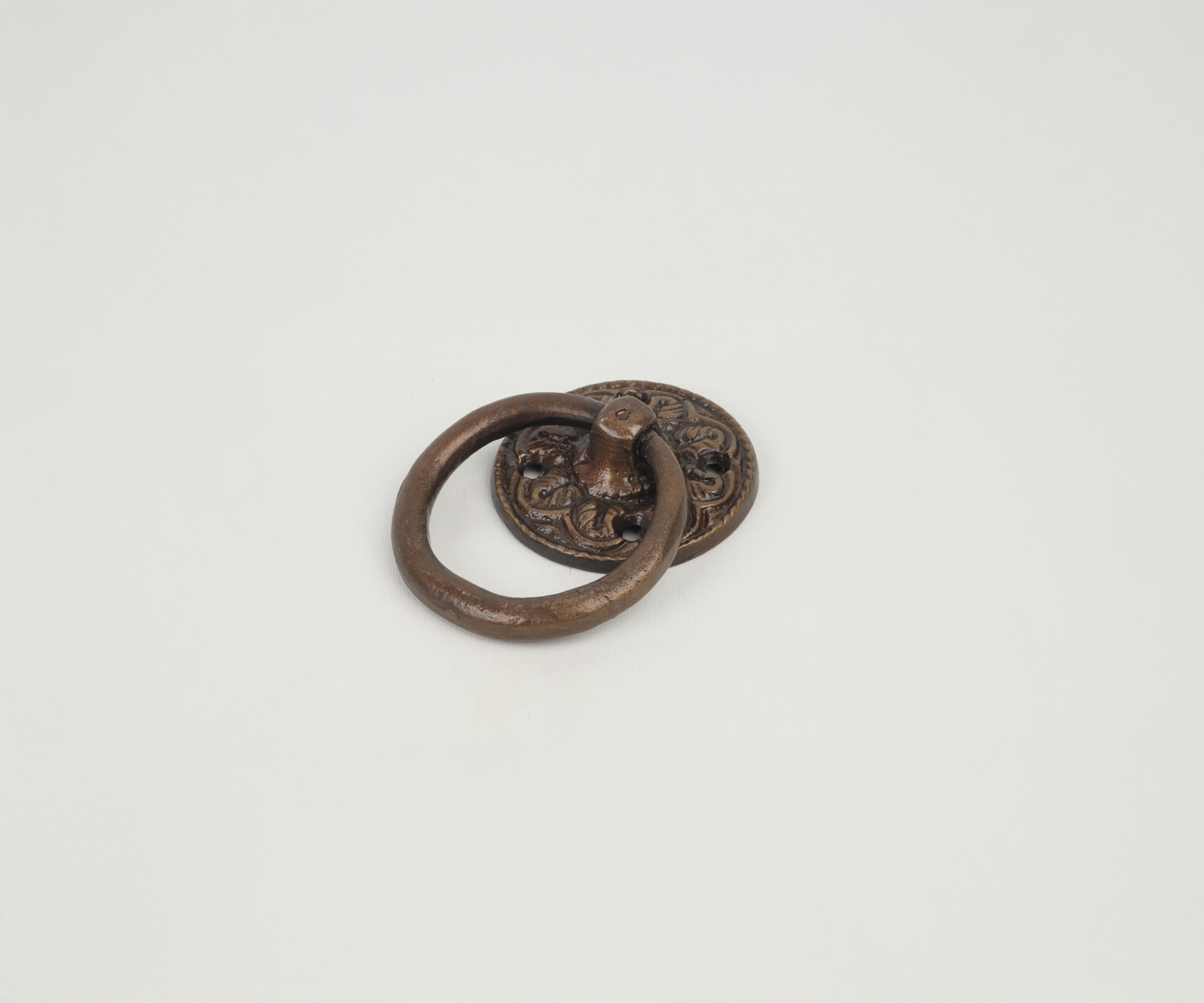 Antique metal door knocker with a decorative backplate on a white background.