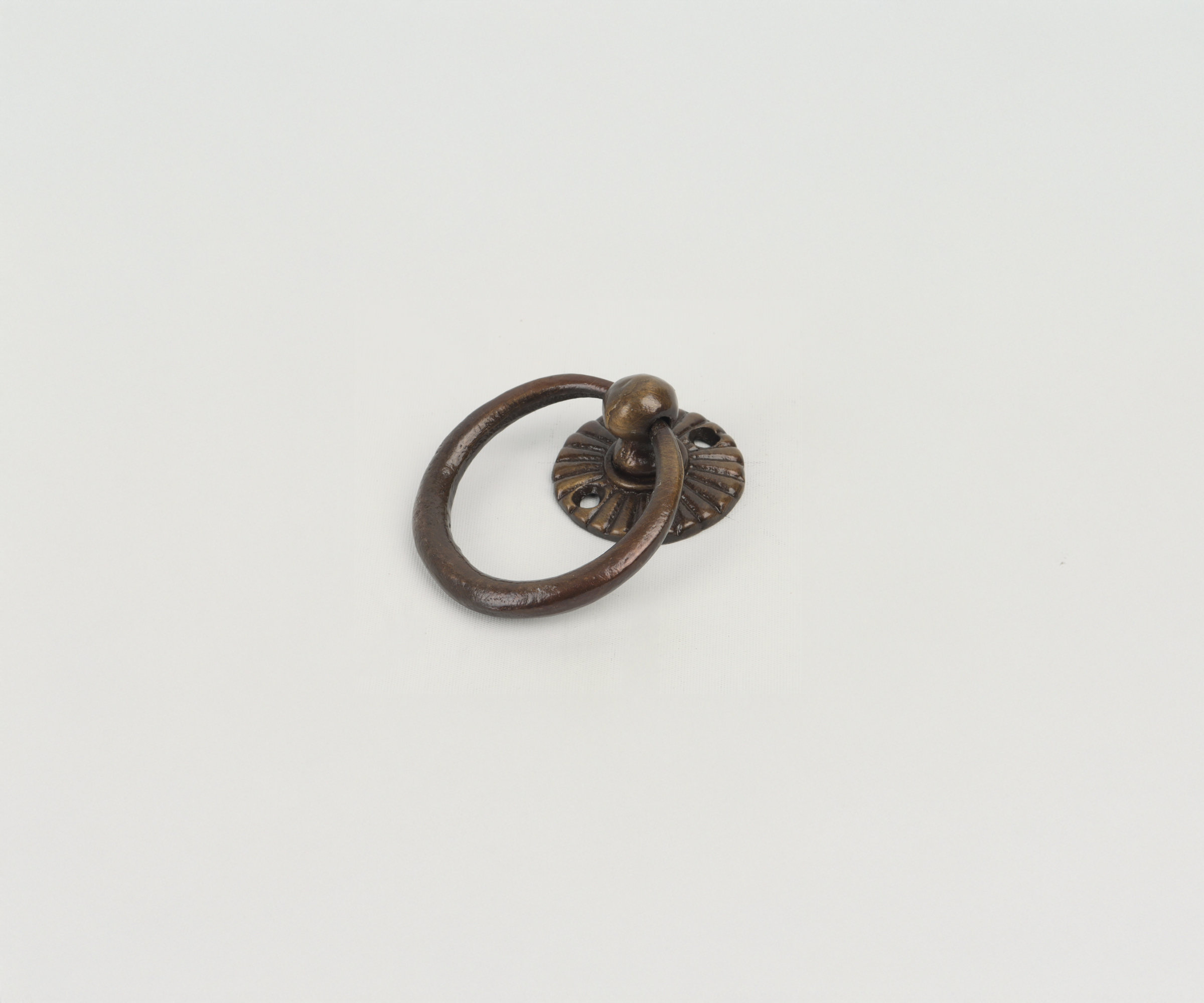 A vintage brass door knocker with a circular ring and a decorative base plate, photographed on a white background.