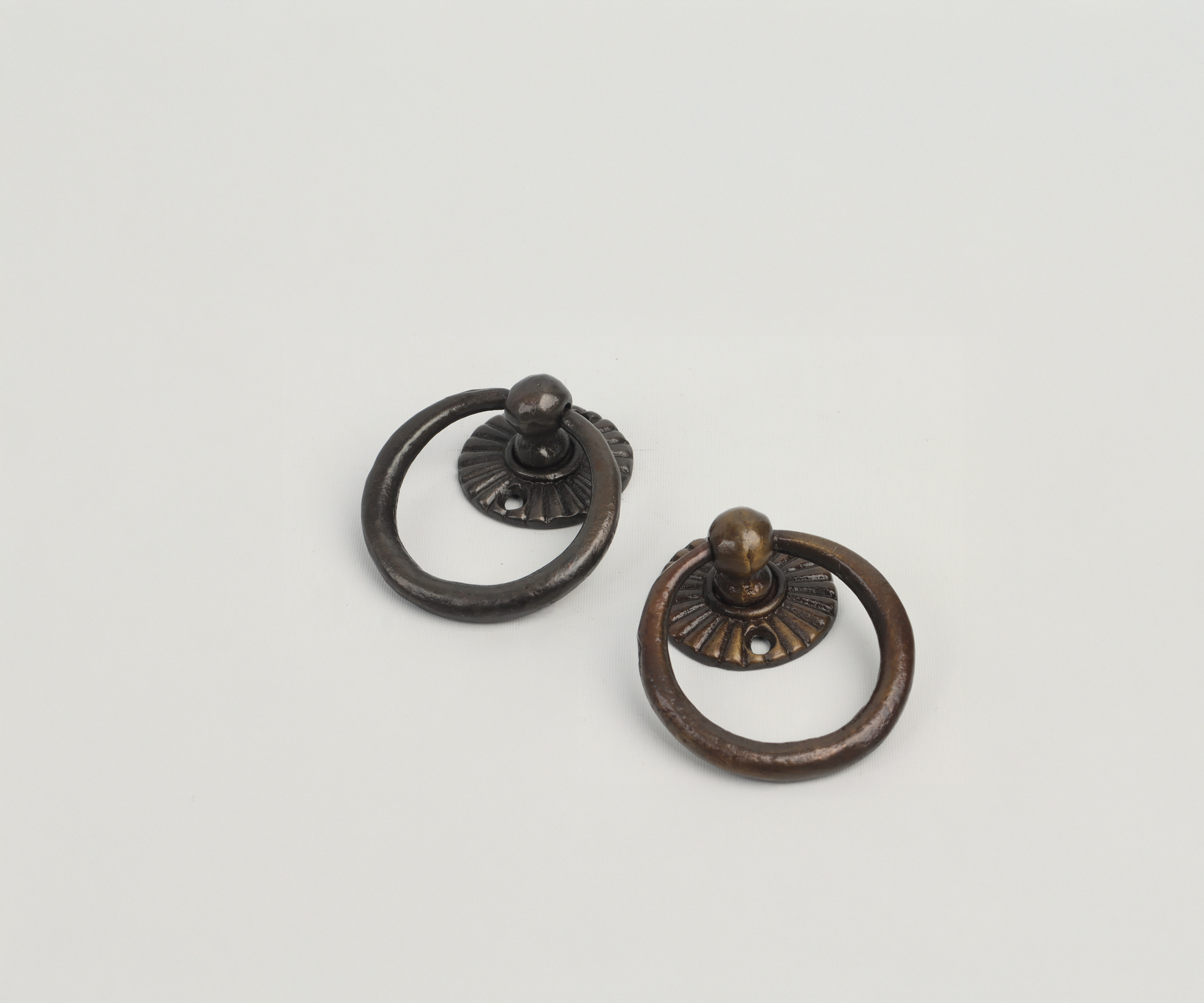 Two vintage-style metal door knockers on a white background, one black and one bronze-colored.