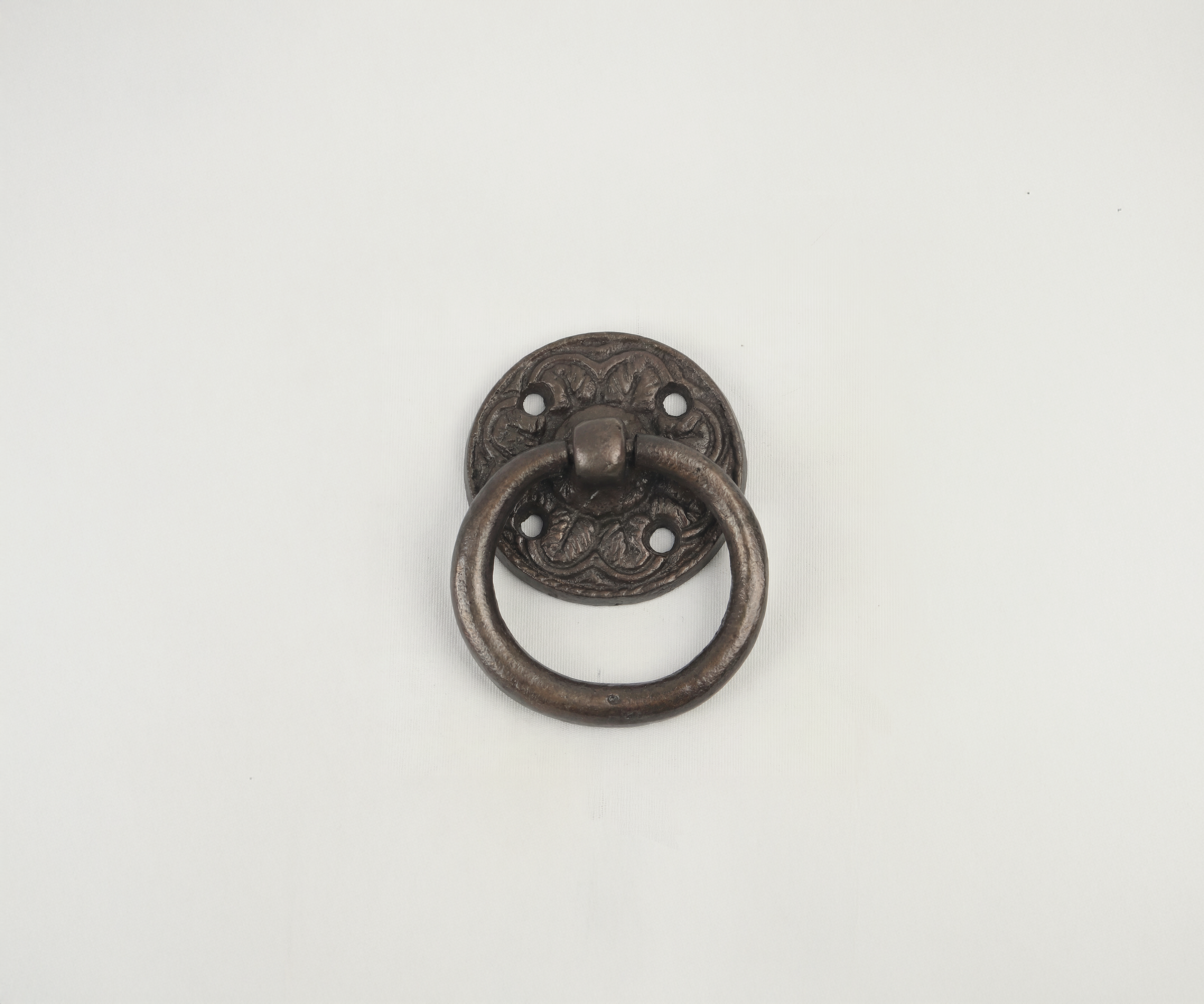 Decorative antique bronze door knocker with a circular ring on a plain white background.