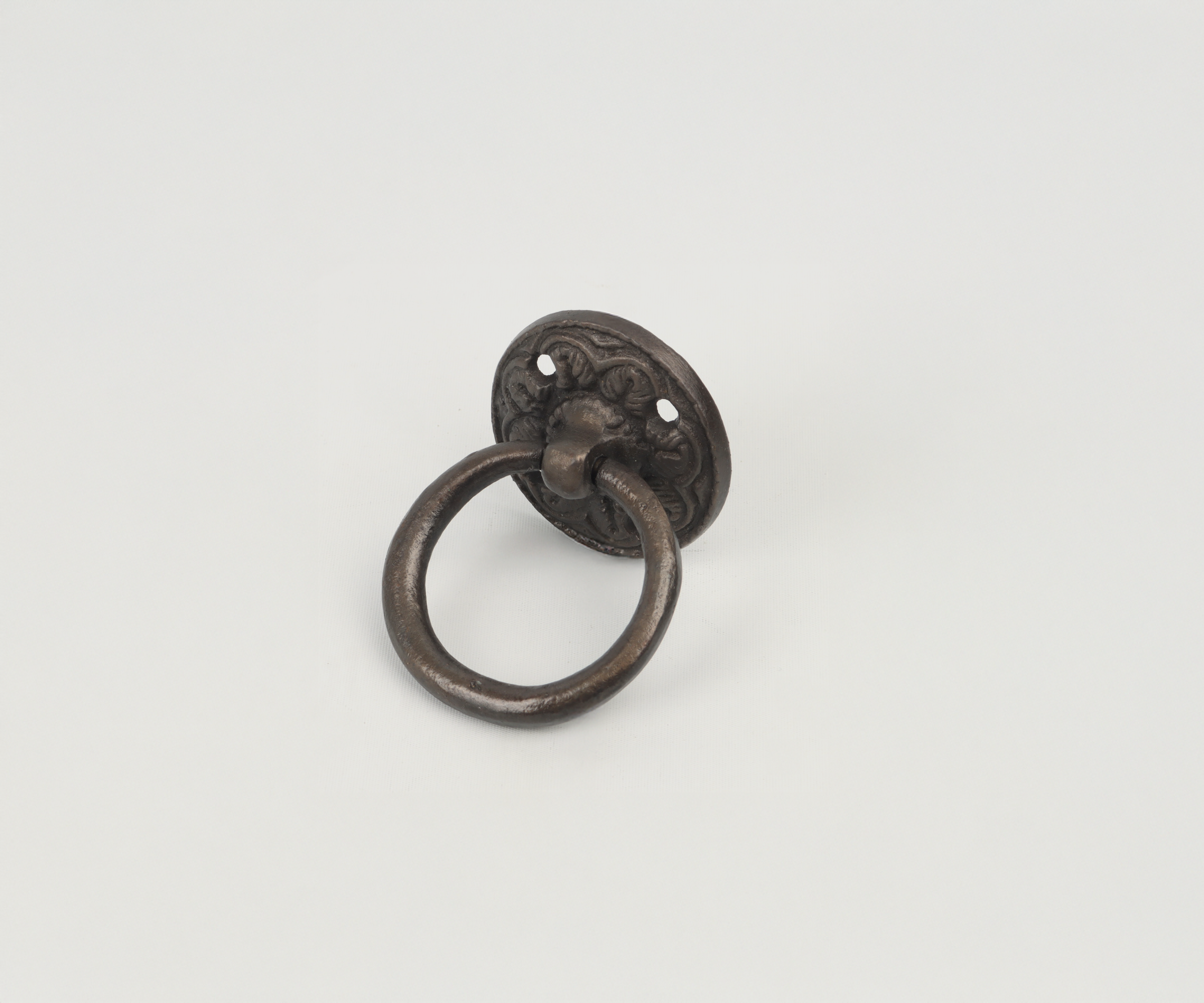 Antique metal door knocker with intricate design on white background.