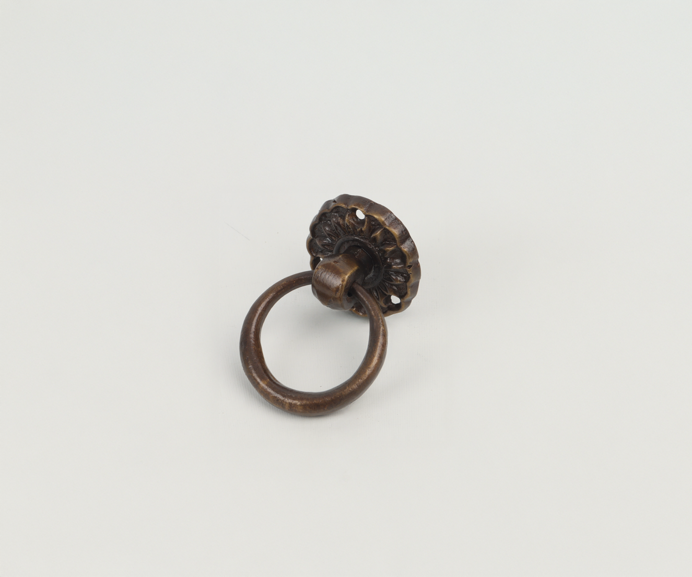 Vintage bronze door knocker with a circular ring on a plain white background.