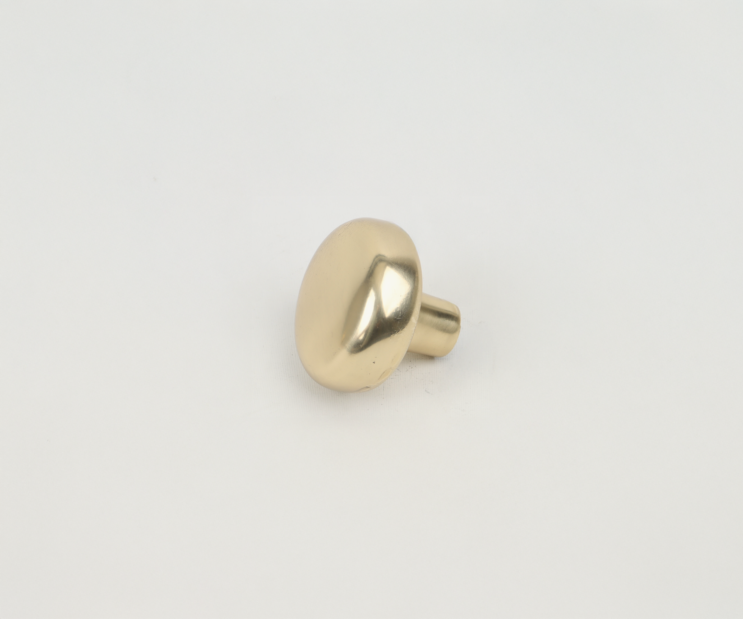 A gold-colored door knob on a white background.