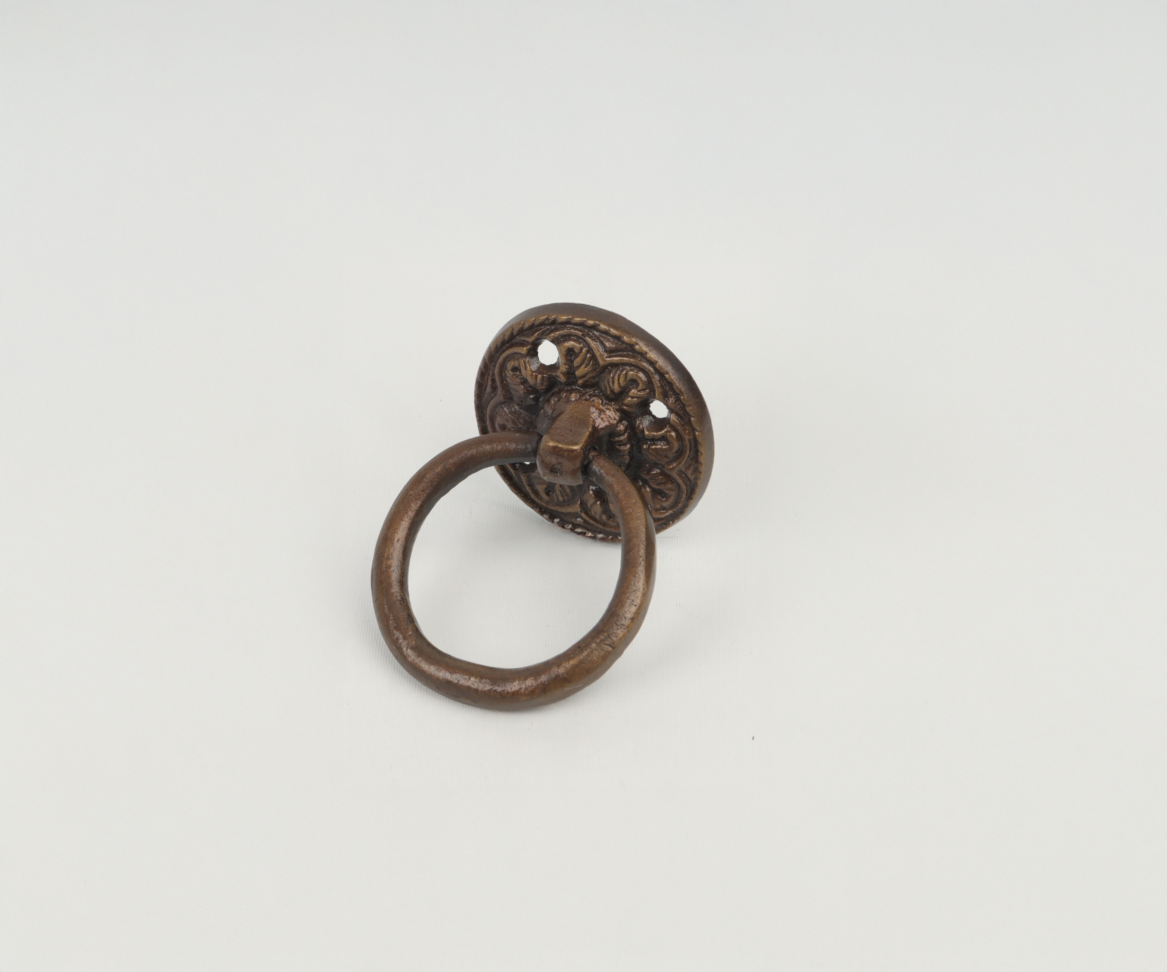 Antique bronze door knocker with ornate design on a white background