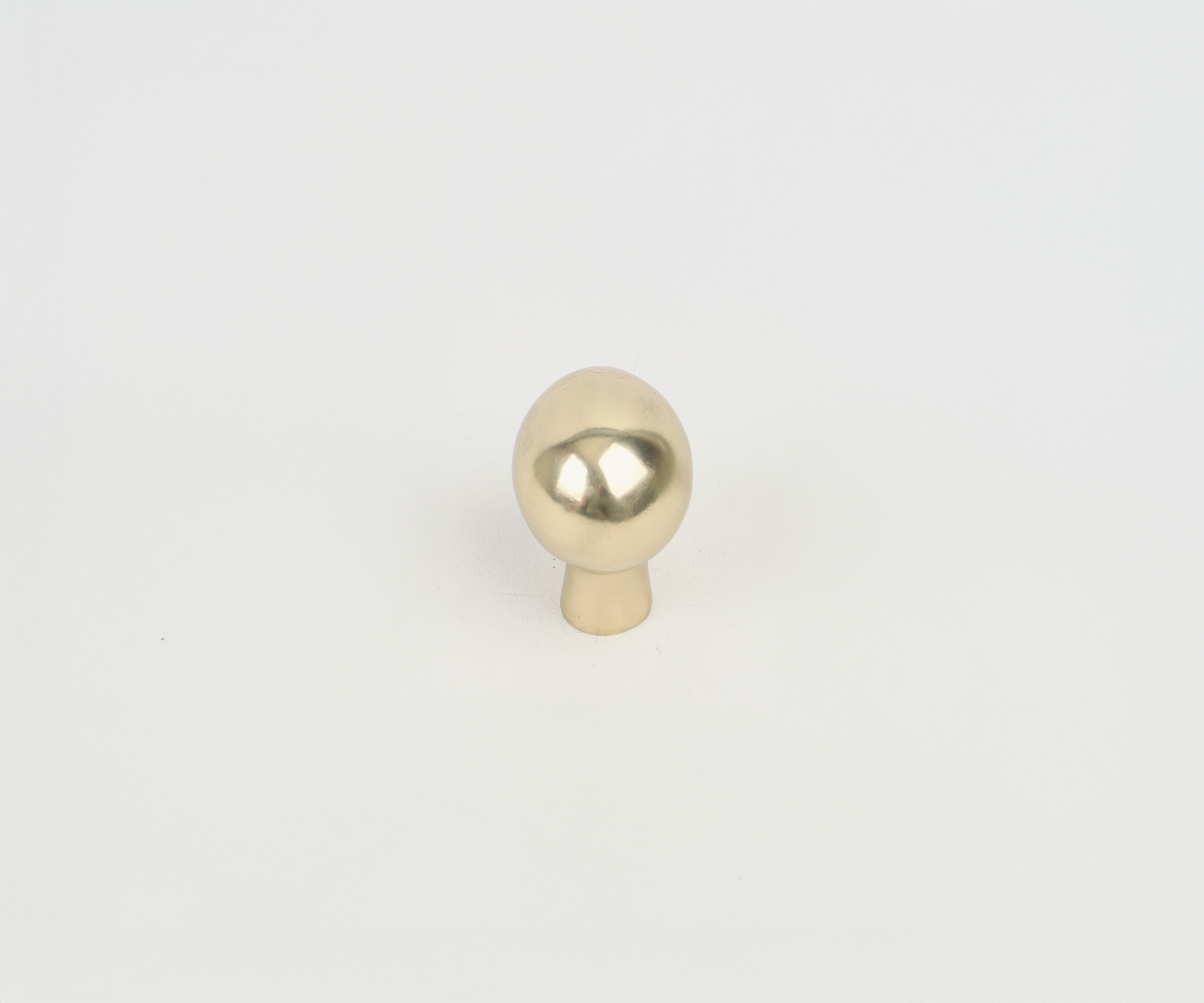 A metallic object resembling a mannequin head with a reflective chrome finish, placed on a white background.