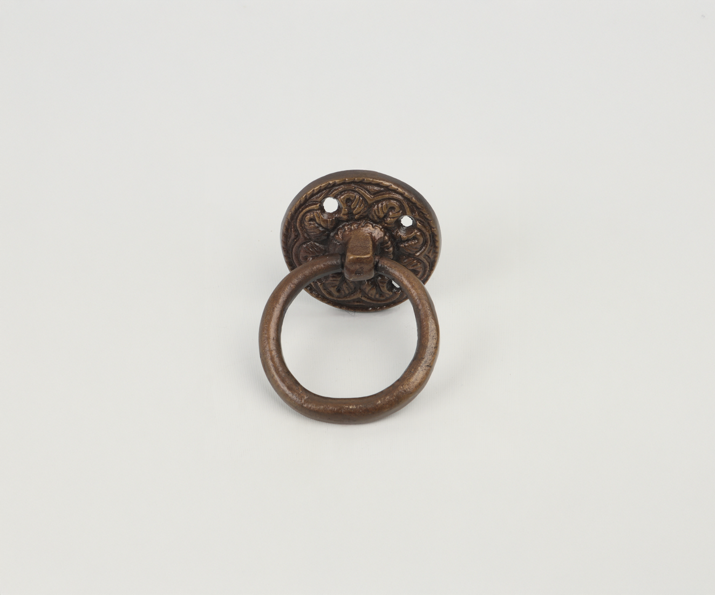 Metal door knocker with ornate backplate and ring, mounted on a plain white background.