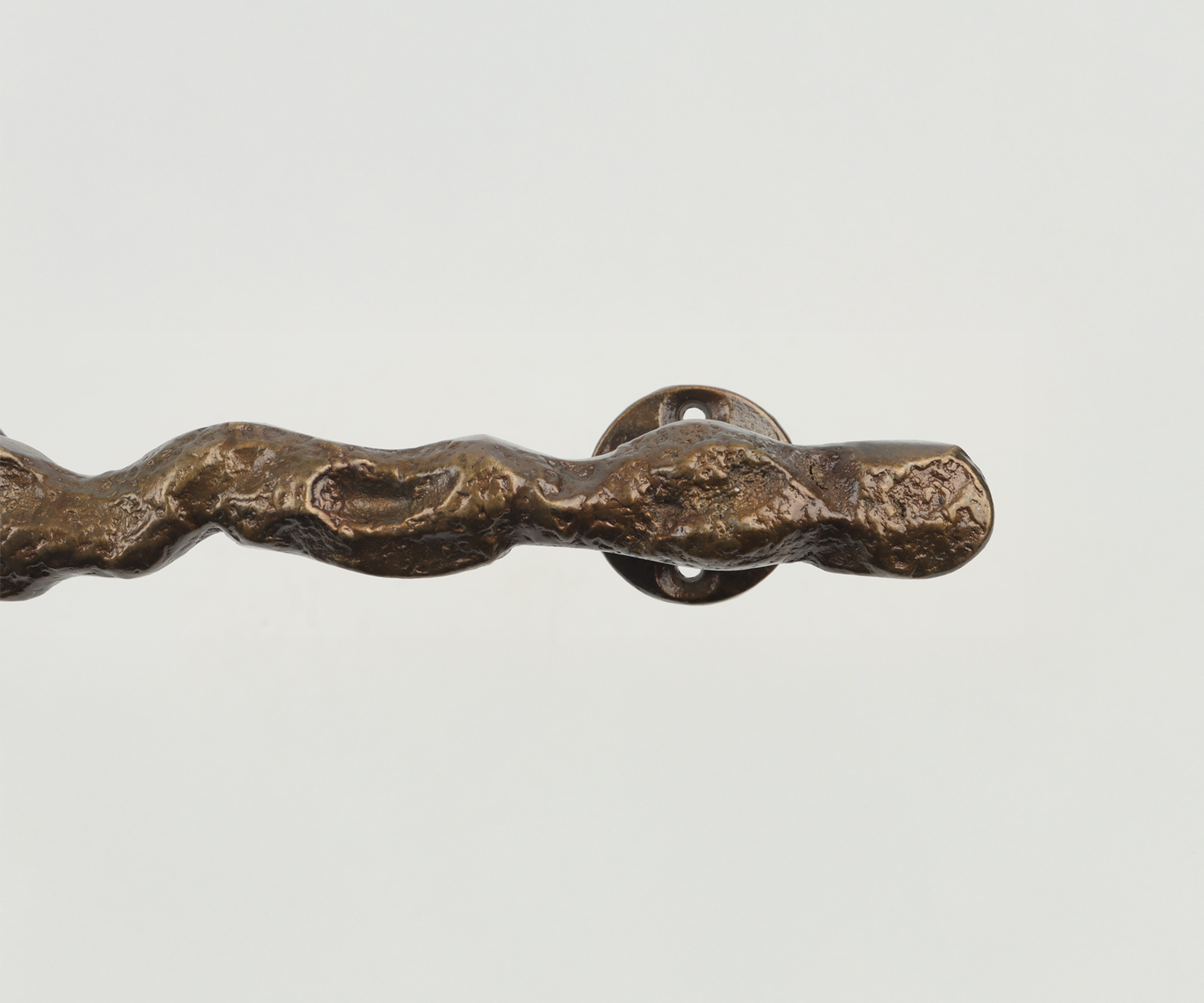 Close-up of an old, weathered door handle with a circular base on a white background.