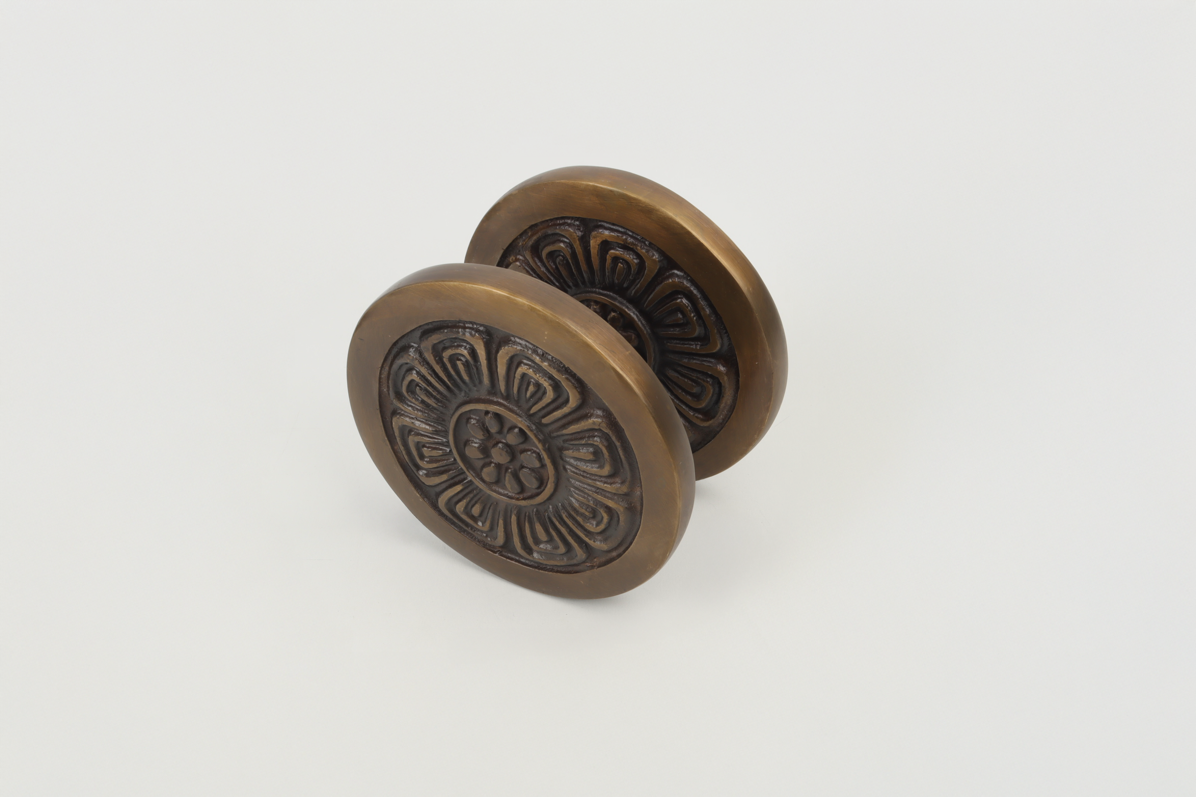 Decorative metal door handles with floral design on a white background