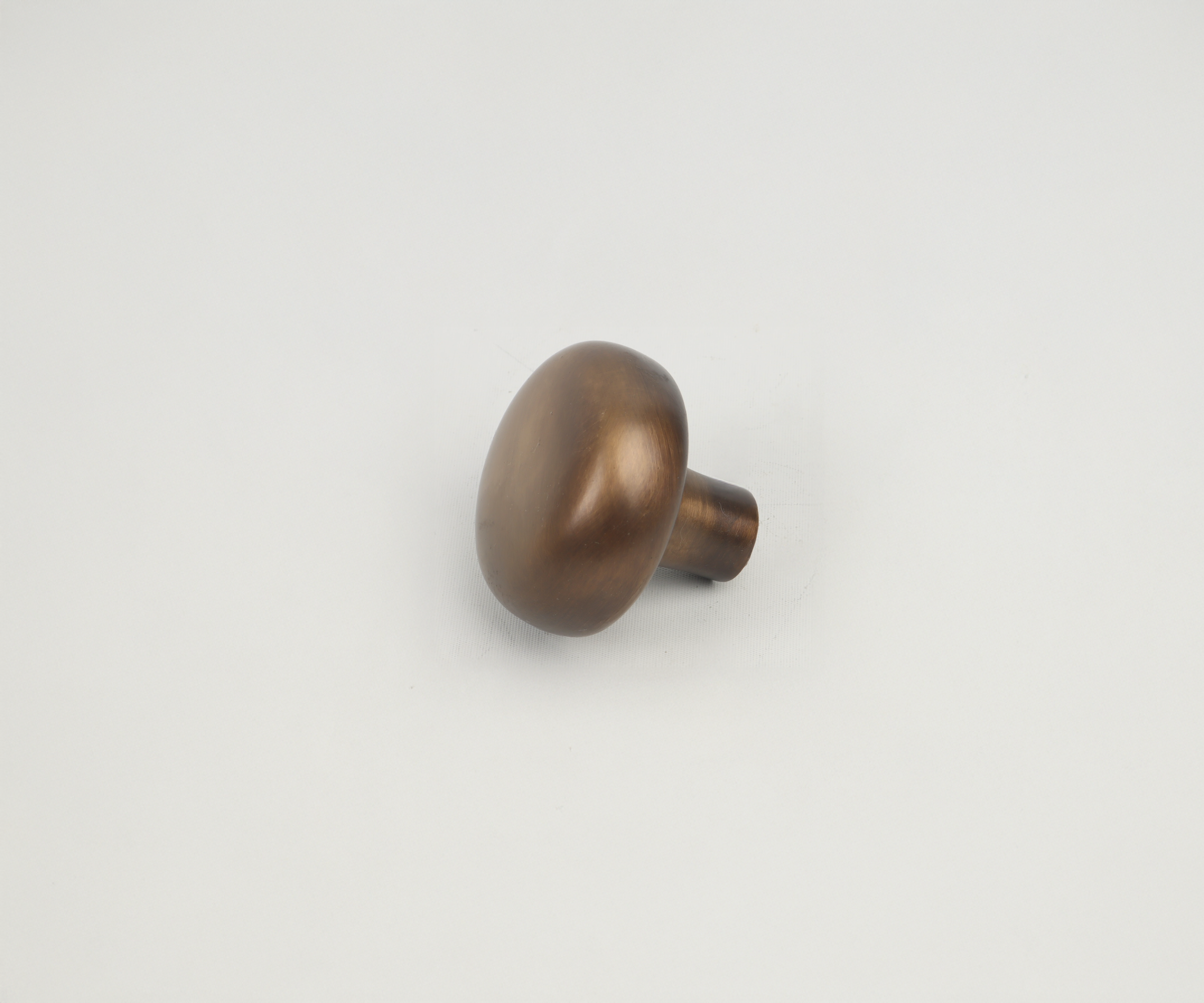 Bronze-colored drawer knob handle on a white background.