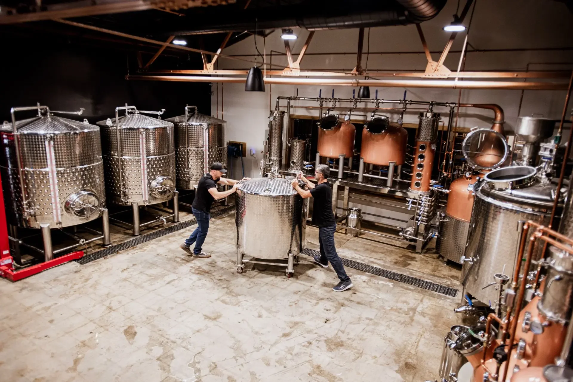 Men pushing a tank in a distillery
