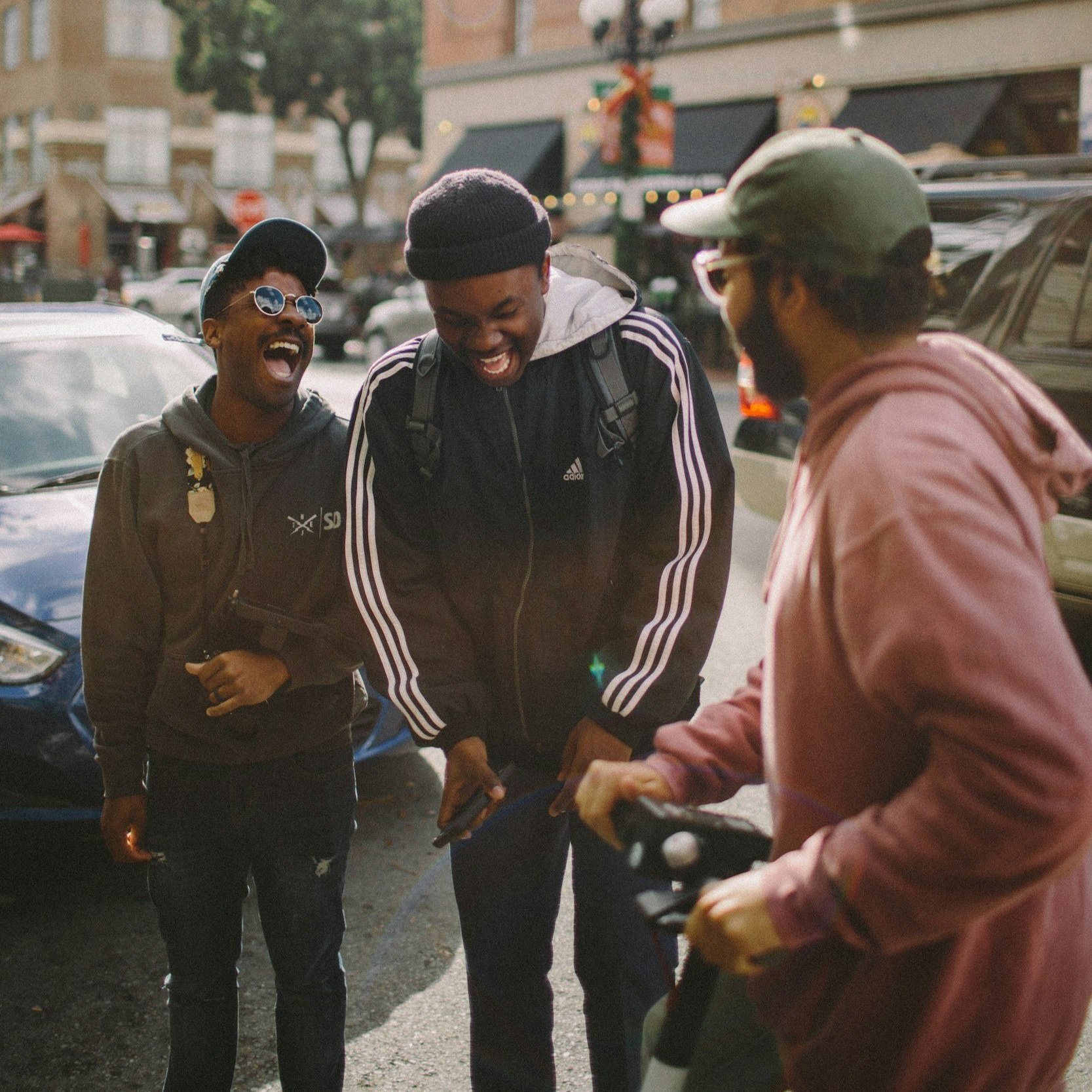 Group of young black men laughing outside a storefront