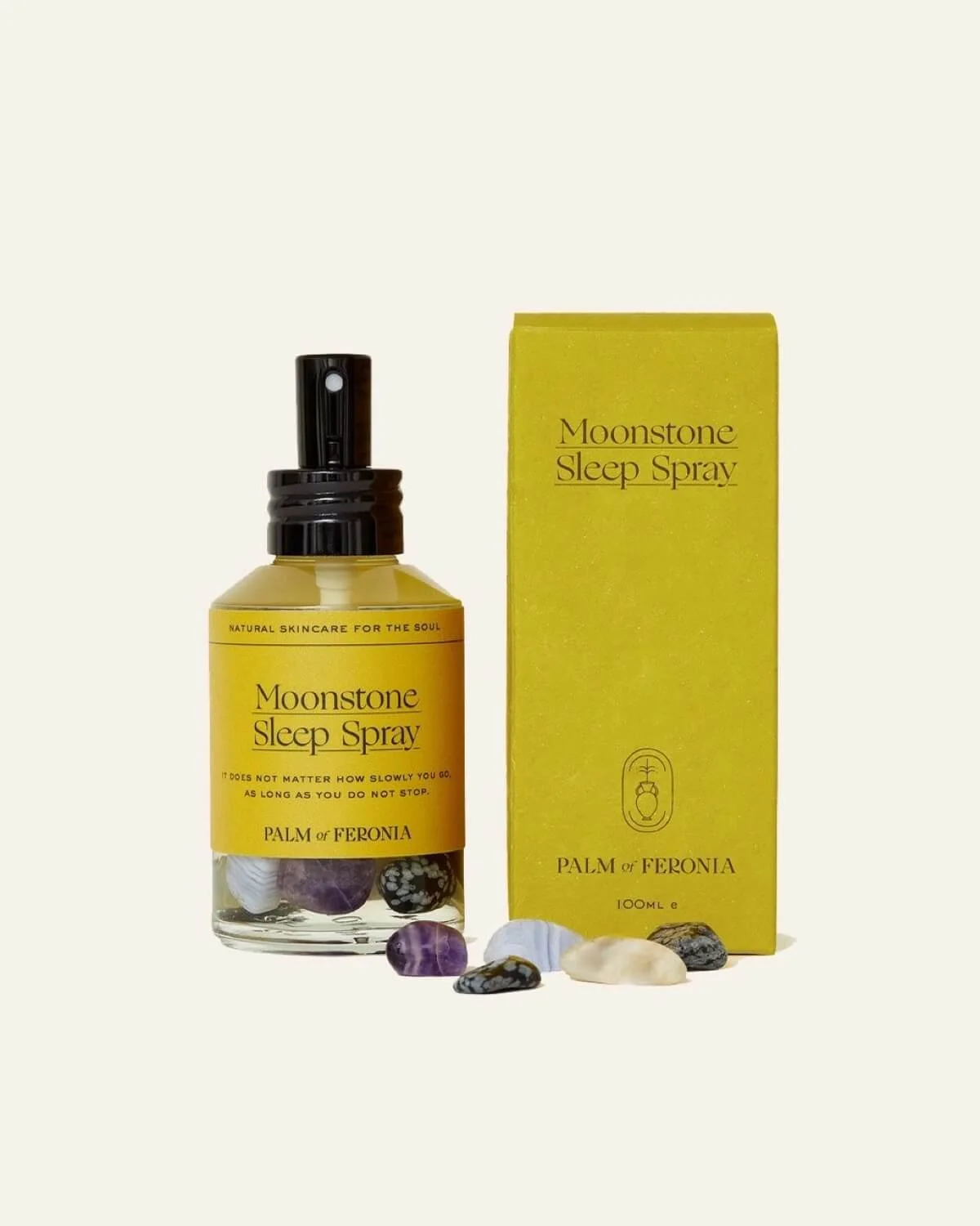 Moonstone Sleep Spray by Palm of Feronia with yellow packaging and loose crystals on a pale background.