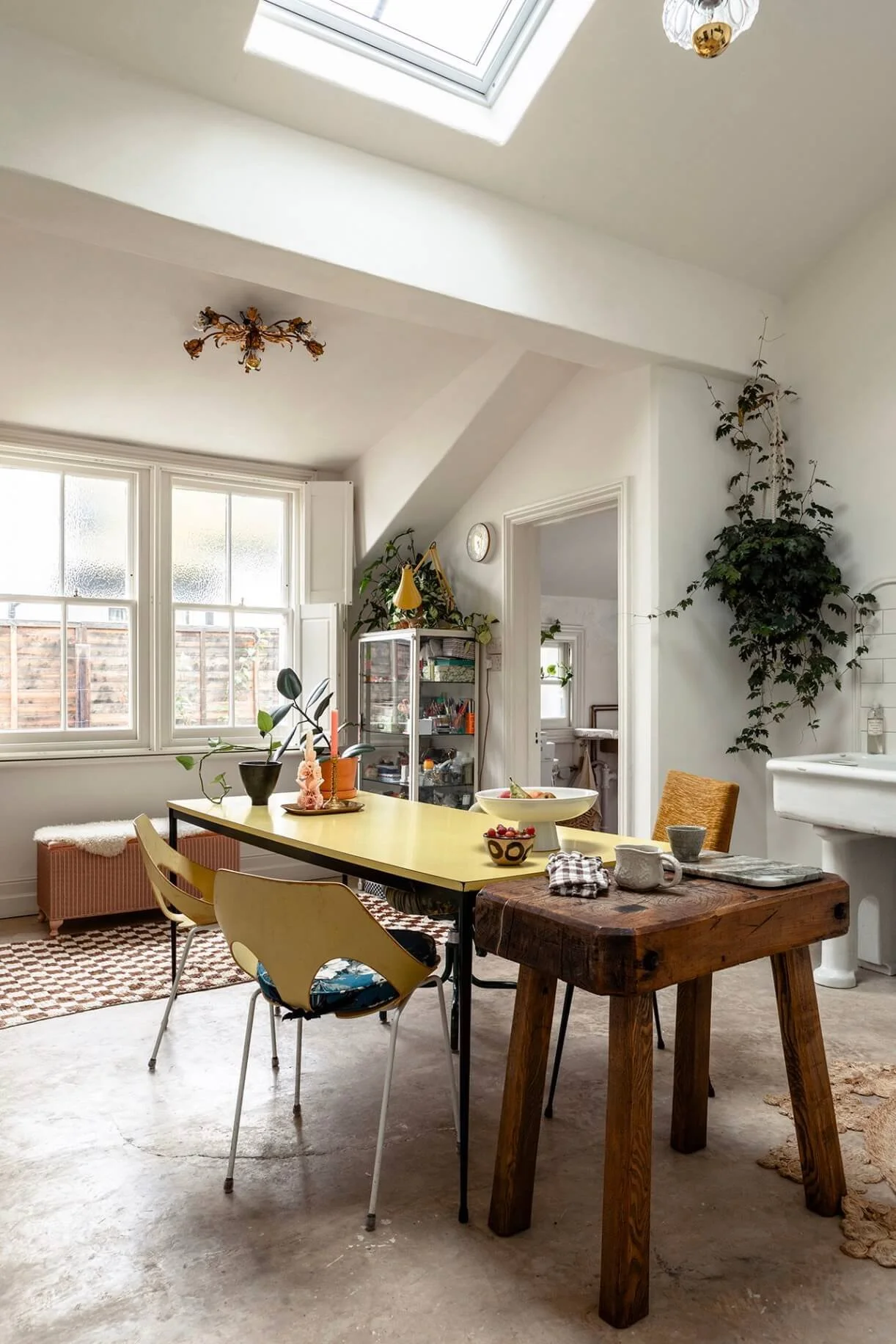 The light-filled Sea Tower kitchen with a yellow table, vintage wooden butcher's block and limecrete flooring.