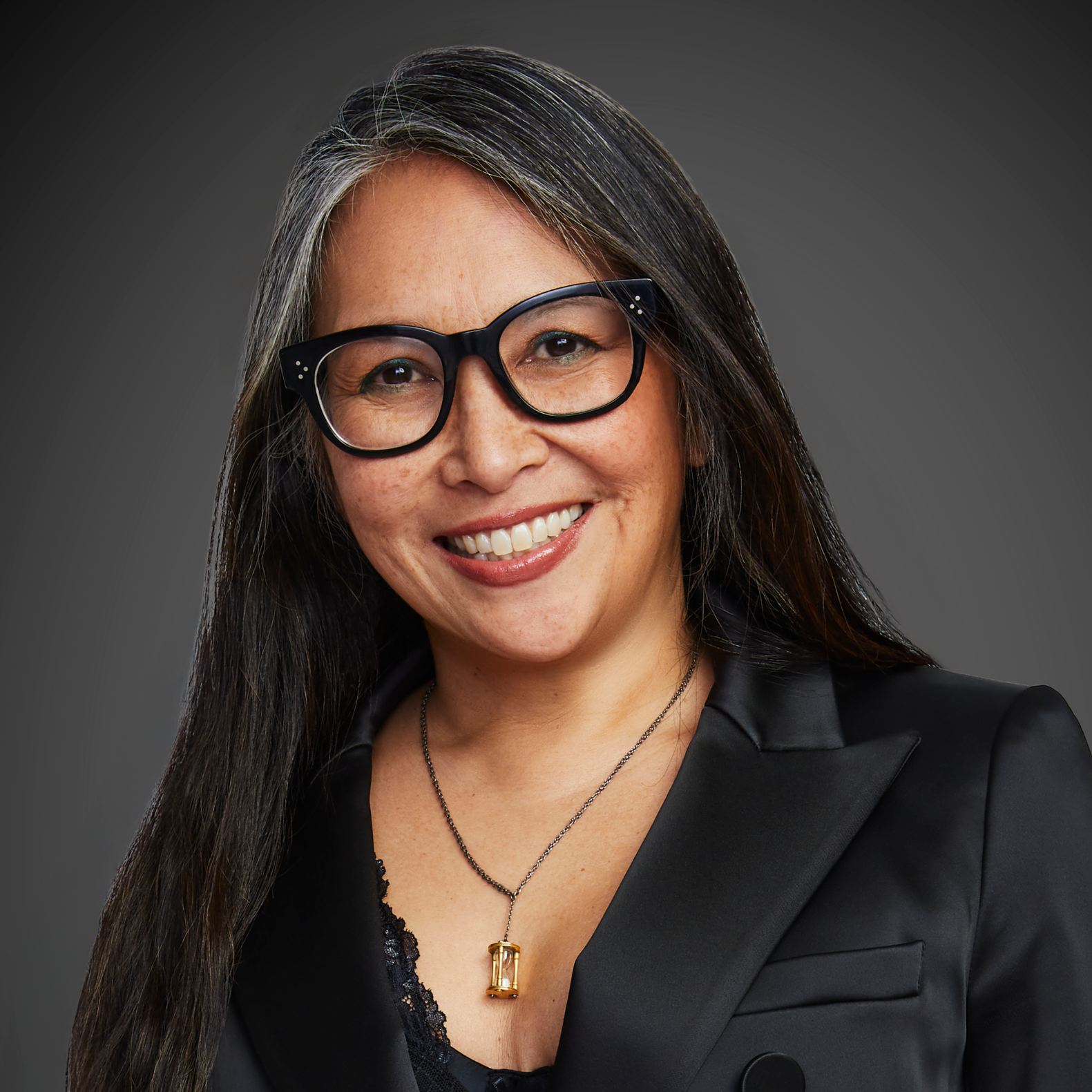 Woman with black glasses and black blazer