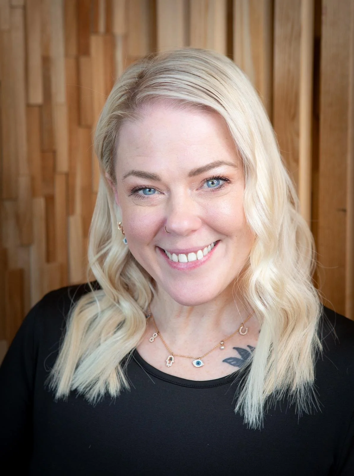 Portrait of a professional hair stylist and salon owner smiling confidently in their modern salon, showcasing their expertise and passion for hair care