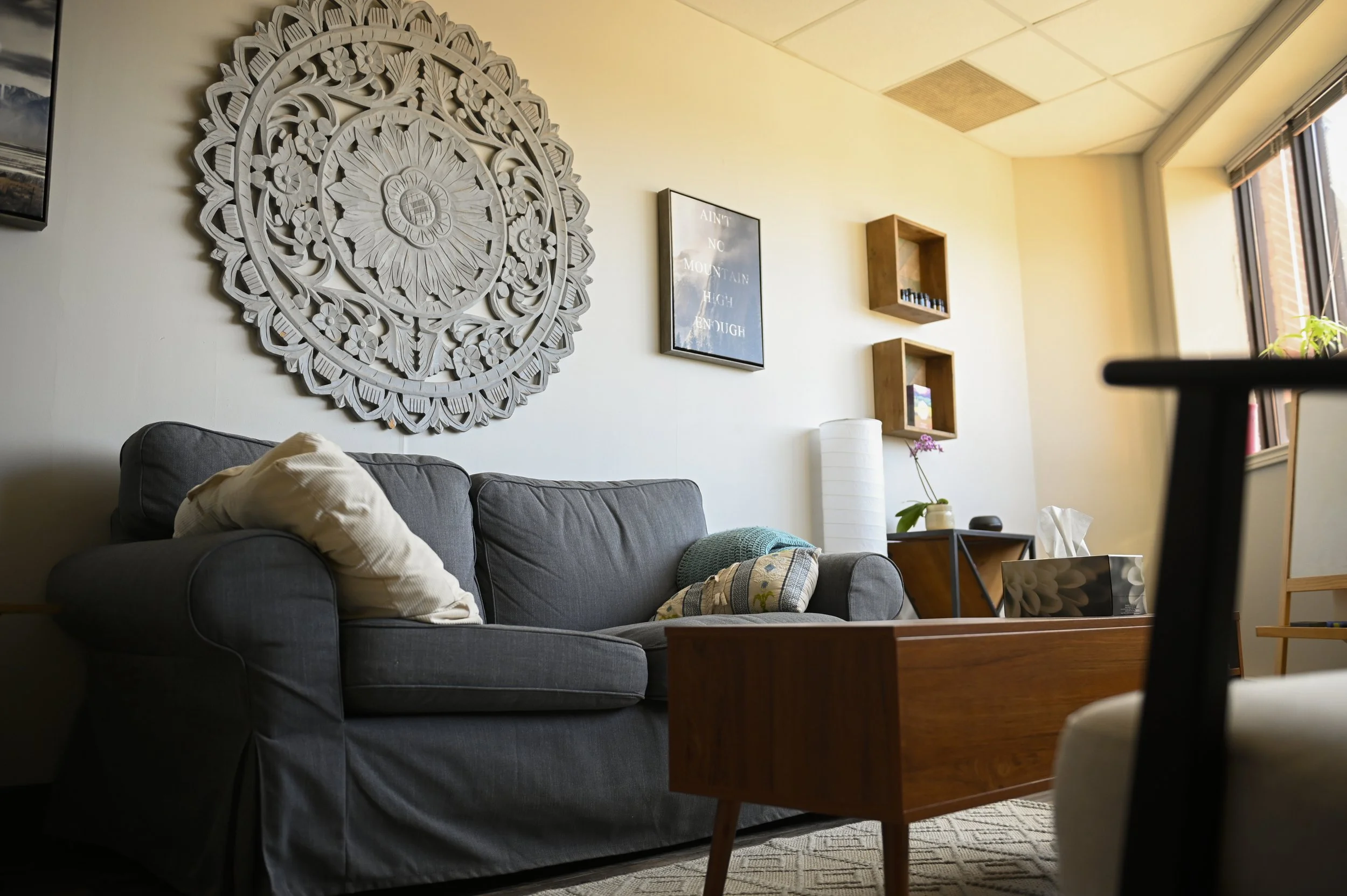 Cozy living room with gray sofa, decorative wall art, and wooden coffee table.