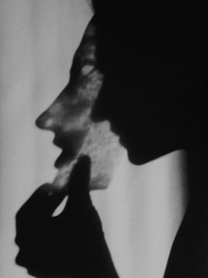 Silhouette of a person holding a mirror reflecting their face, creating an illusion of two profiles touching.