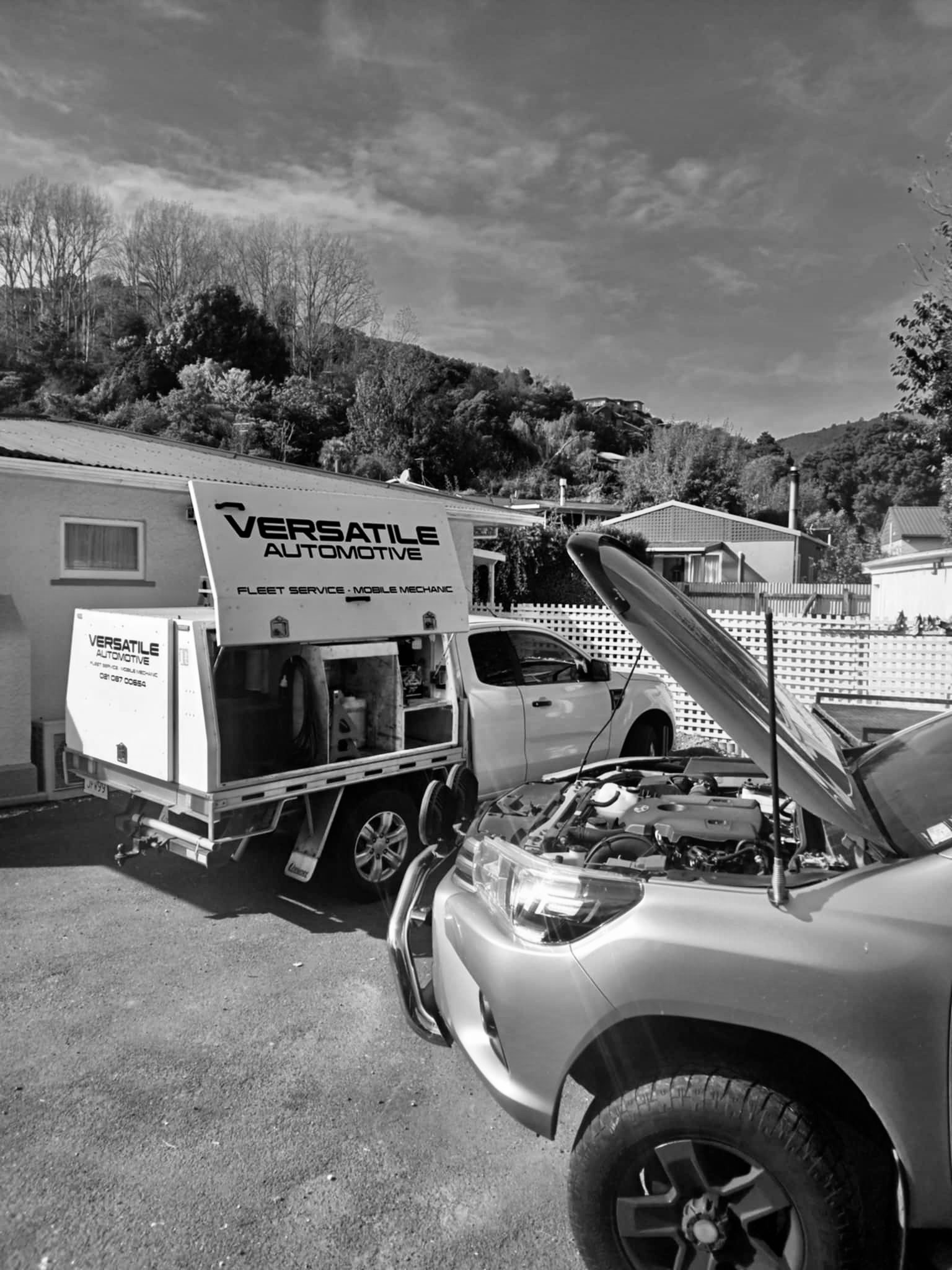 The Versatile Automotive truck parked at a customer's address as Dave works on a car with the bonnet up.