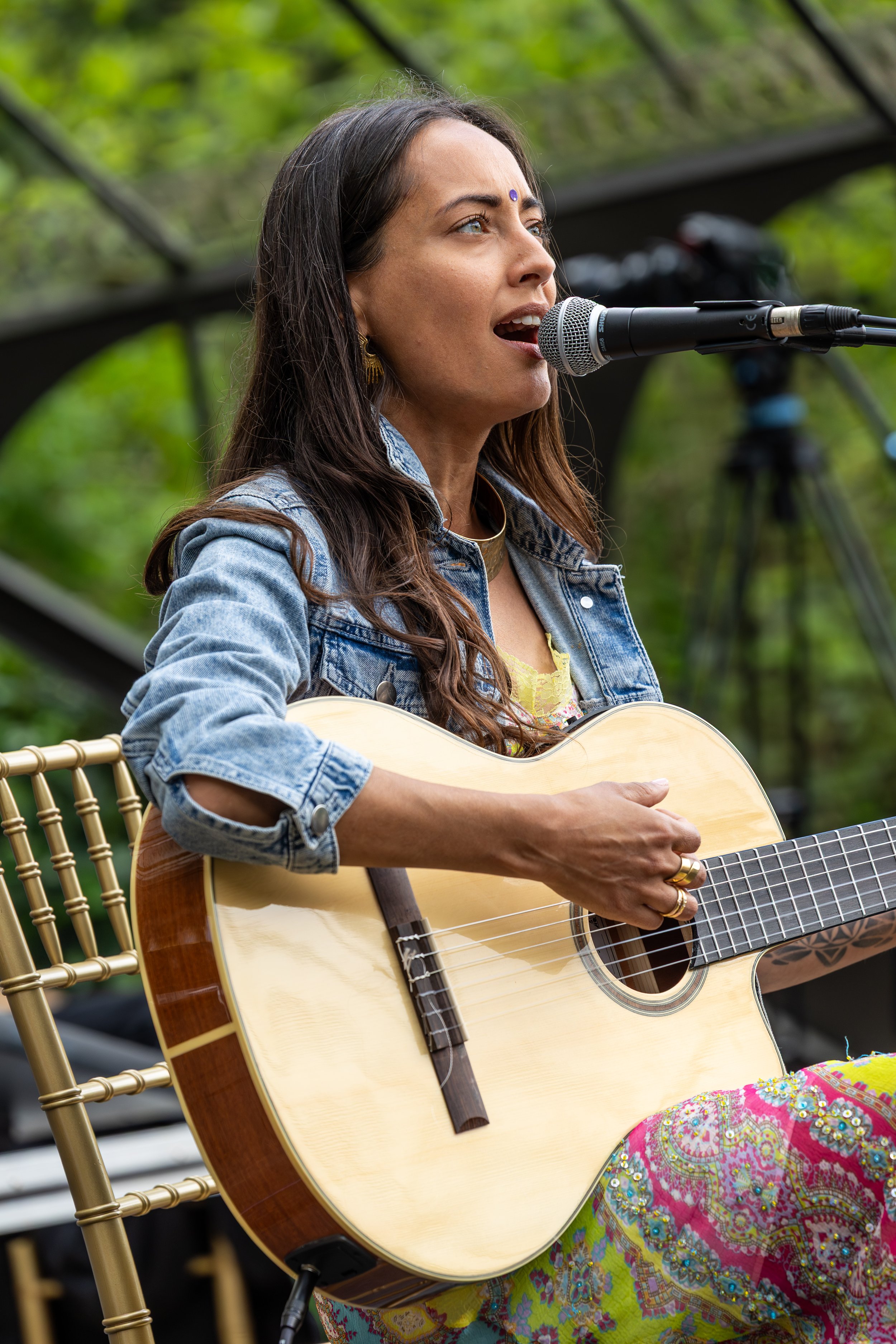 Reachel Singh playing an acoustic guitar and singing, performing during FiVth Experience in Portugal.