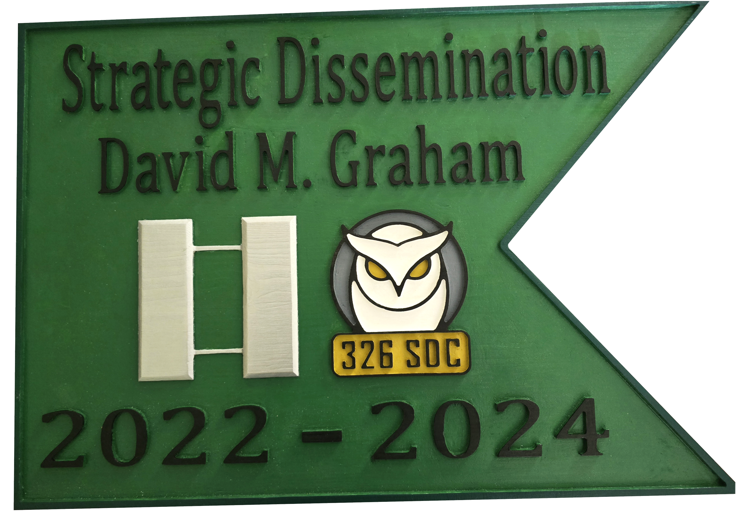 Green plaque with black text reading "Strategic Dissemination David M. Graham 2022-2024" and a white owl logo with yellow eyes and a yellow label "326 SOC."