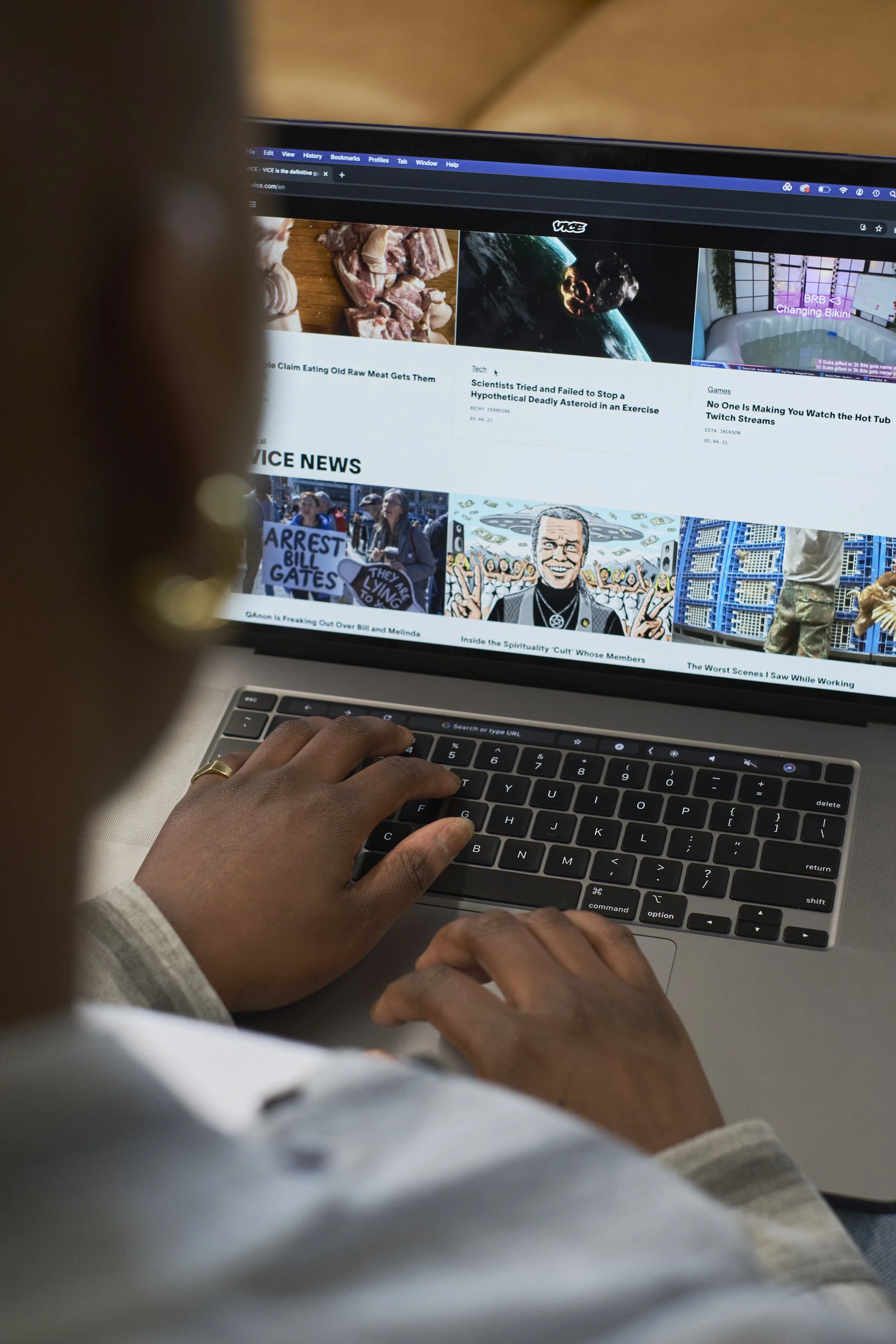 Person browsing the Vice website on a laptop, with news articles and headlines visible on the screen.